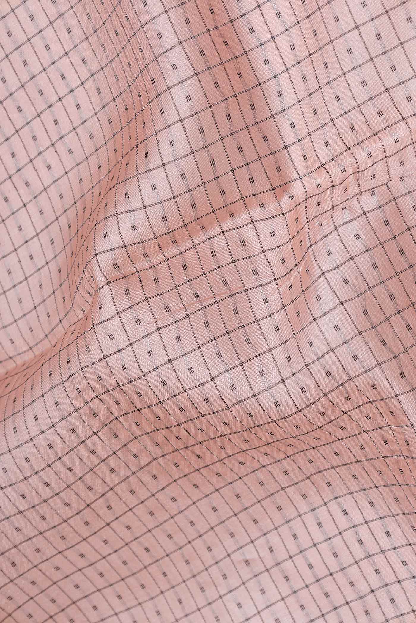 Close up of Rose Gold Tussar Silk Saree with Checked design on the body and Embroidery Border displaying folds