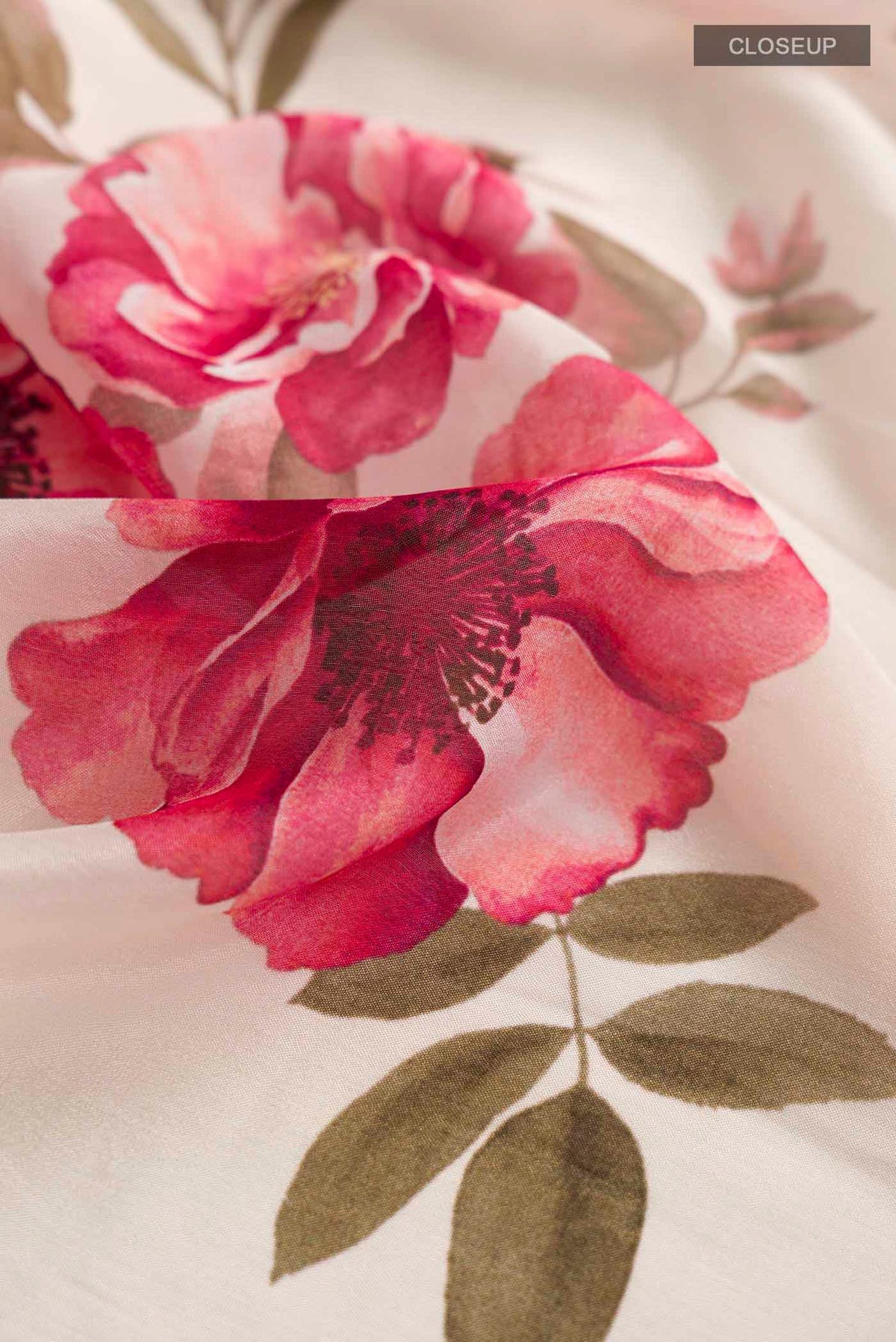 Close up of Cream Crepe SareePrinted design on the body and Embroidery Border displaying folds