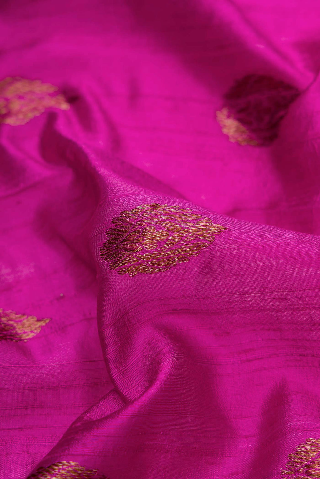Close up of Magenta Dual Tone Raw Silk Saree with Zari Butta on the body and Zari Border displaying folds