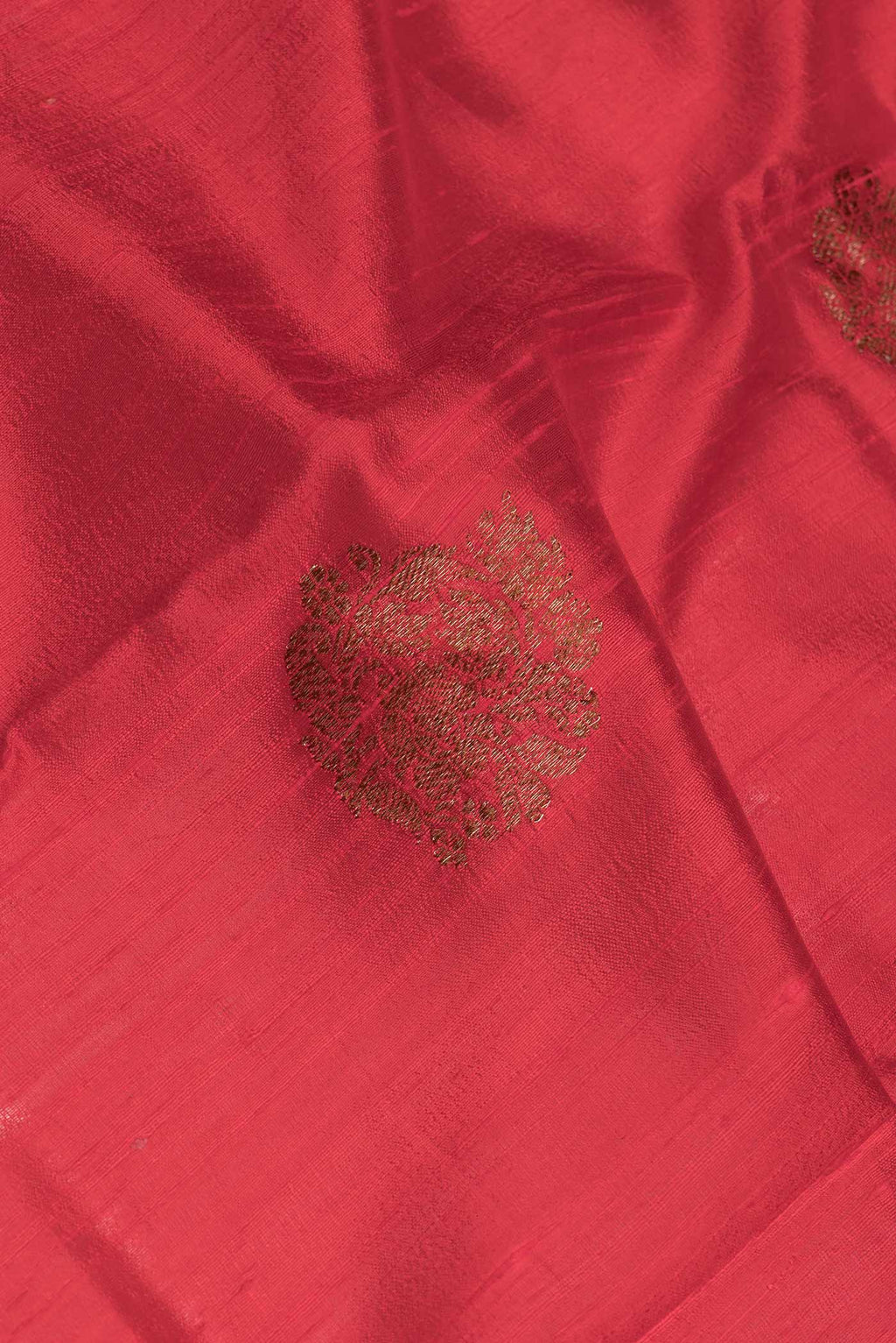 Close up of Red Dual Tone Tussar Saree with Zari Butta on the body and Zari And Thread Border.  displaying folds