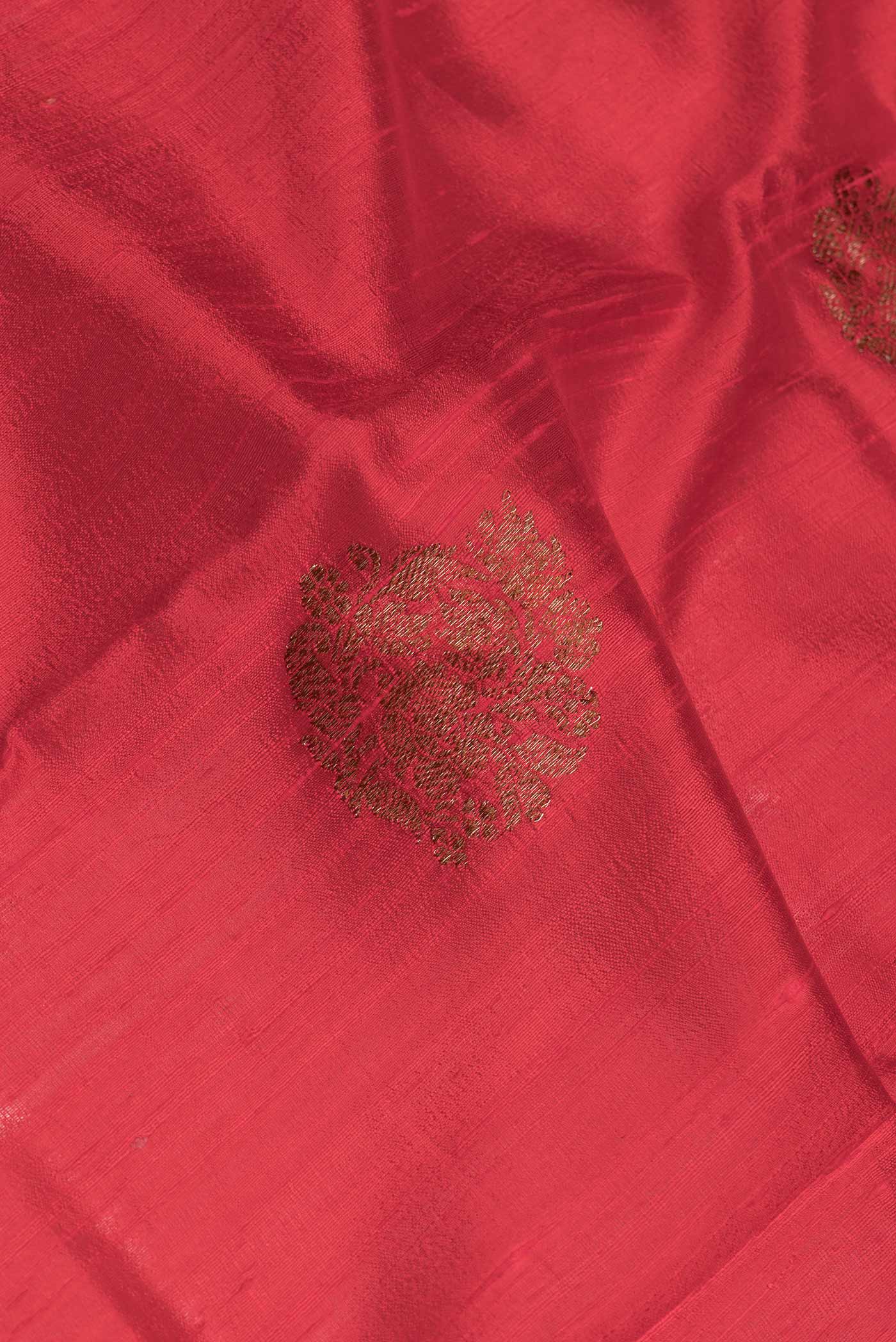 Close up of Red Dual Tone Tussar Saree with Zari Butta on the body and Zari And Thread Border.  displaying folds