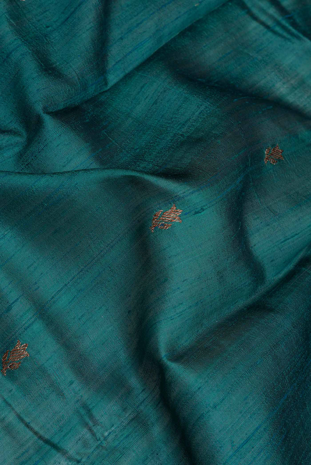 Close up of Green Dual Tone Tussar Saree with Zari Butta on the body and Zari And Thread Border.  displaying folds