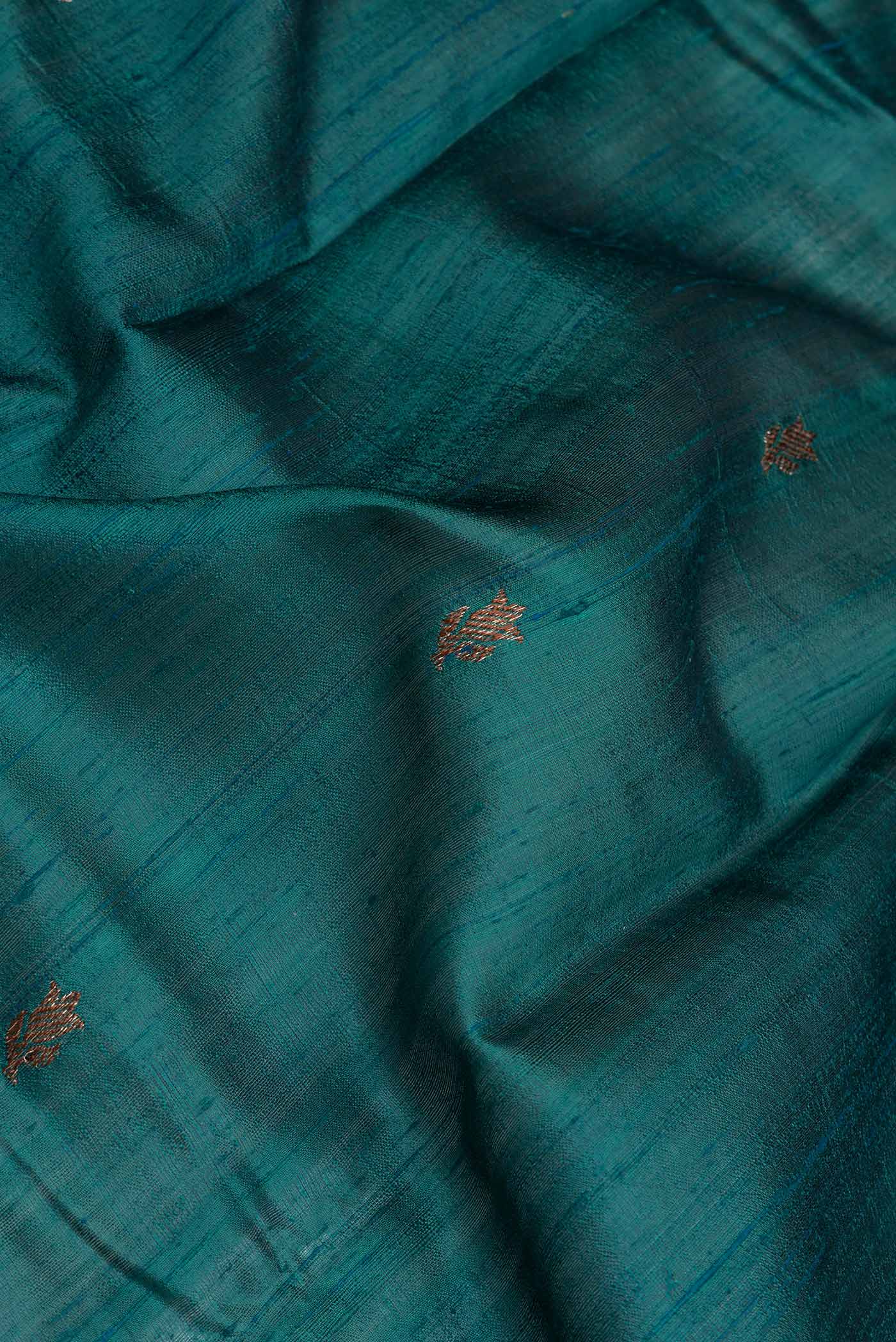 Close up of Green Dual Tone Tussar Saree with Zari Butta on the body and Zari And Thread Border.  displaying folds