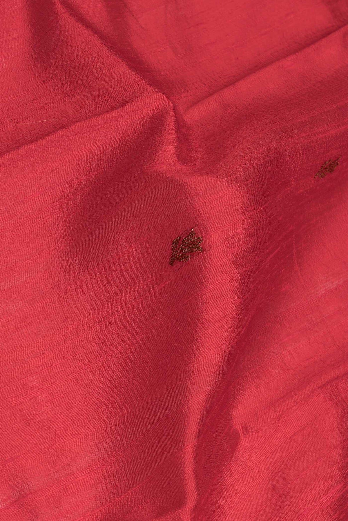 Close up of Red Dual Tone Tussar Saree with Zari Butta on the body and Zari And Thread Border.  displaying folds