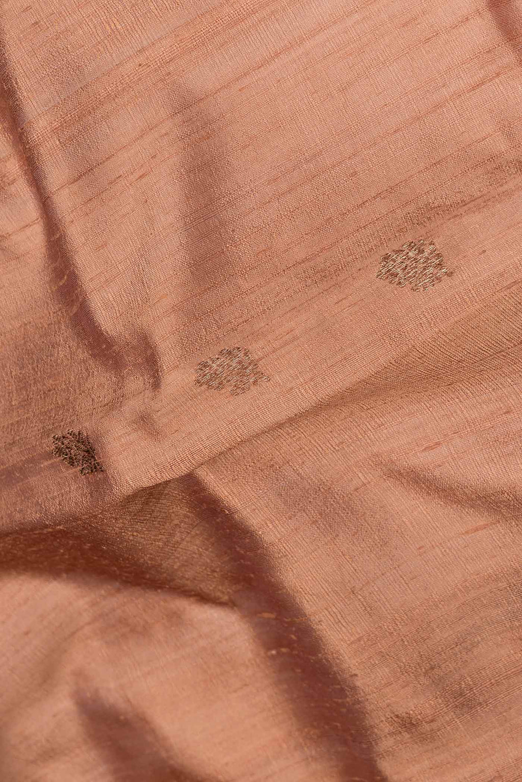 Close up of Brown Dual Tone Tussar Saree with Zari Butta on the body and Zari And Thread Border.  displaying folds