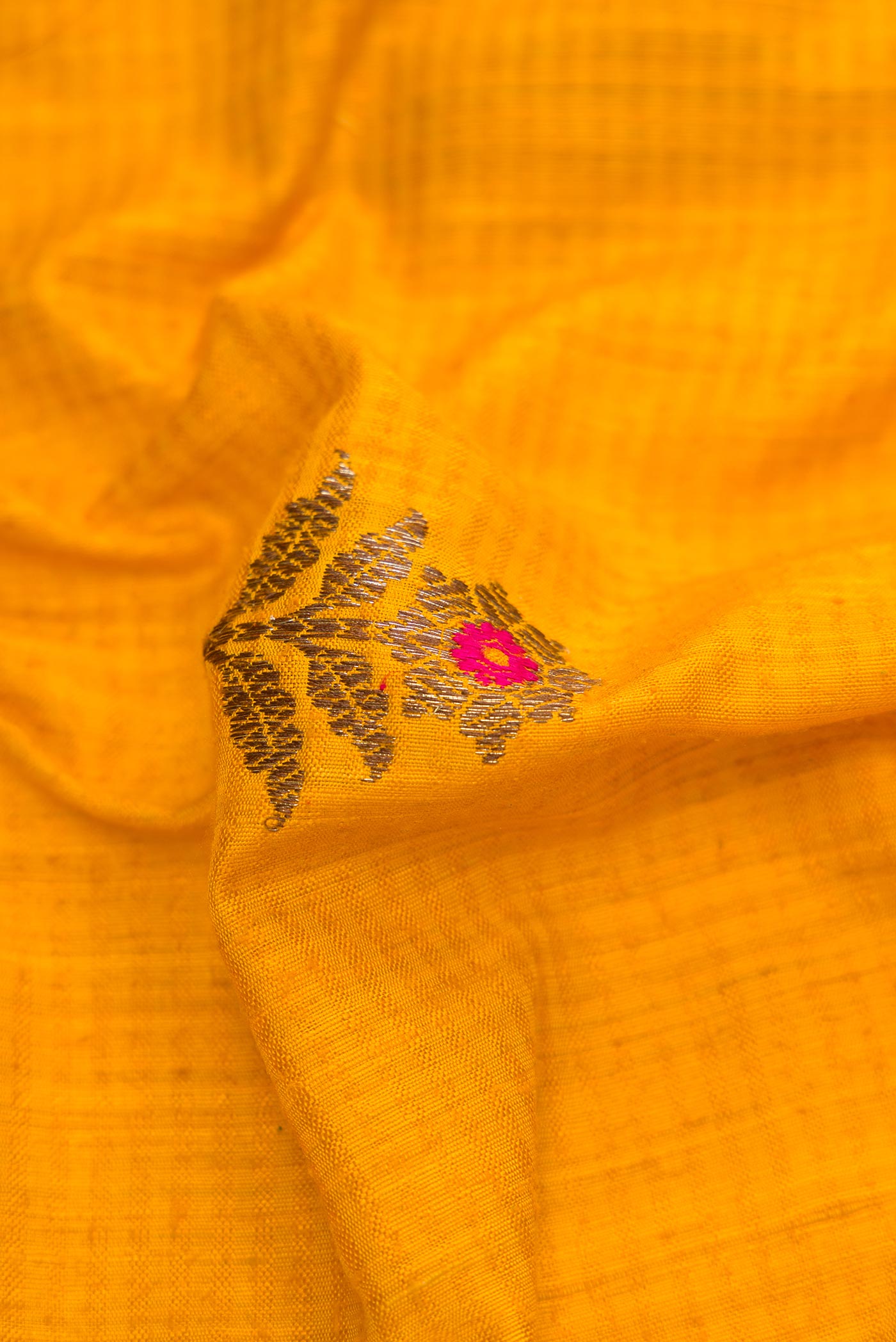 Close up of Yellow Banarasi Tussar Silk Saree with Zari And Thread Butta on the body and Zari Border displaying folds