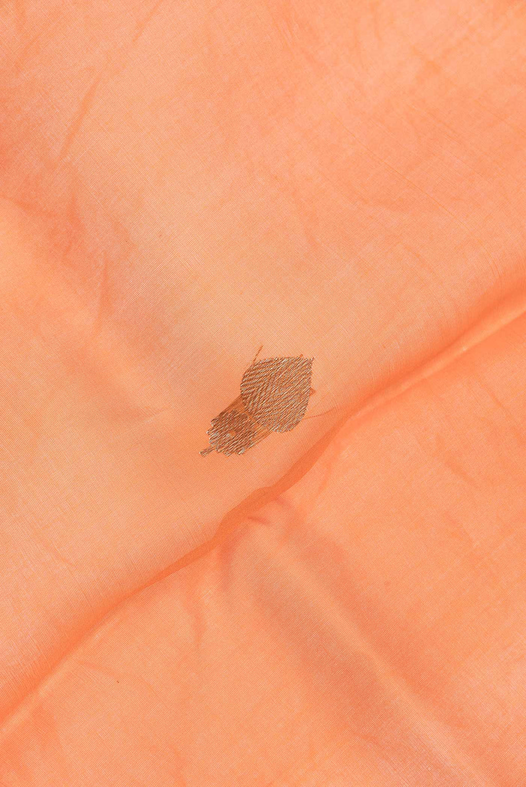 Close up of Peach Dual Tone Organza Silk Saree with Zari Butta on the body and Zari Border.  displaying folds