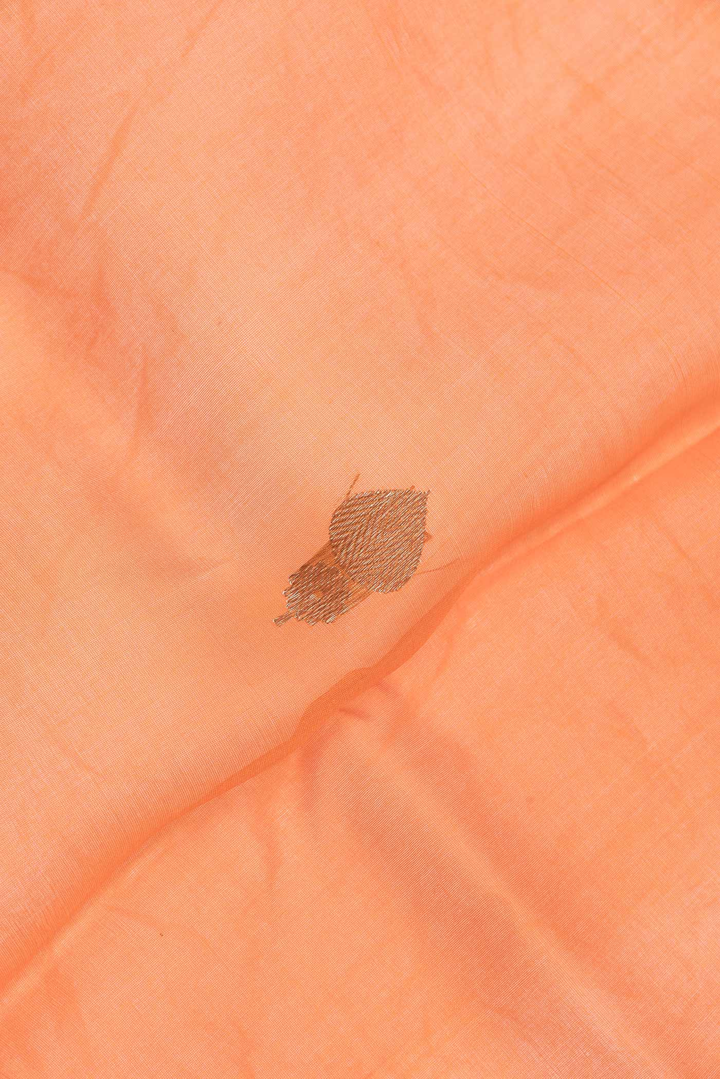 Close up of Peach Dual Tone Organza Silk Saree with Zari Butta on the body and Zari Border.  displaying folds