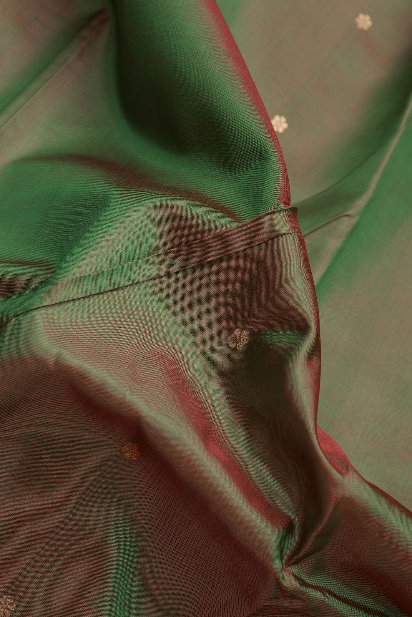 Close up of Mehandi Green Dual Tone Banarasi Silk Saree with Zari Butta on the body and Zari Border.  displaying folds