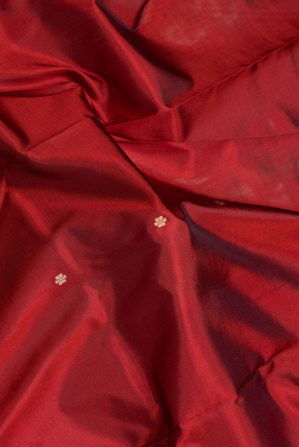 Close up of Maroon Dual Tone Banarasi Silk Saree with Zari Butta on the body and Zari Border.  displaying folds