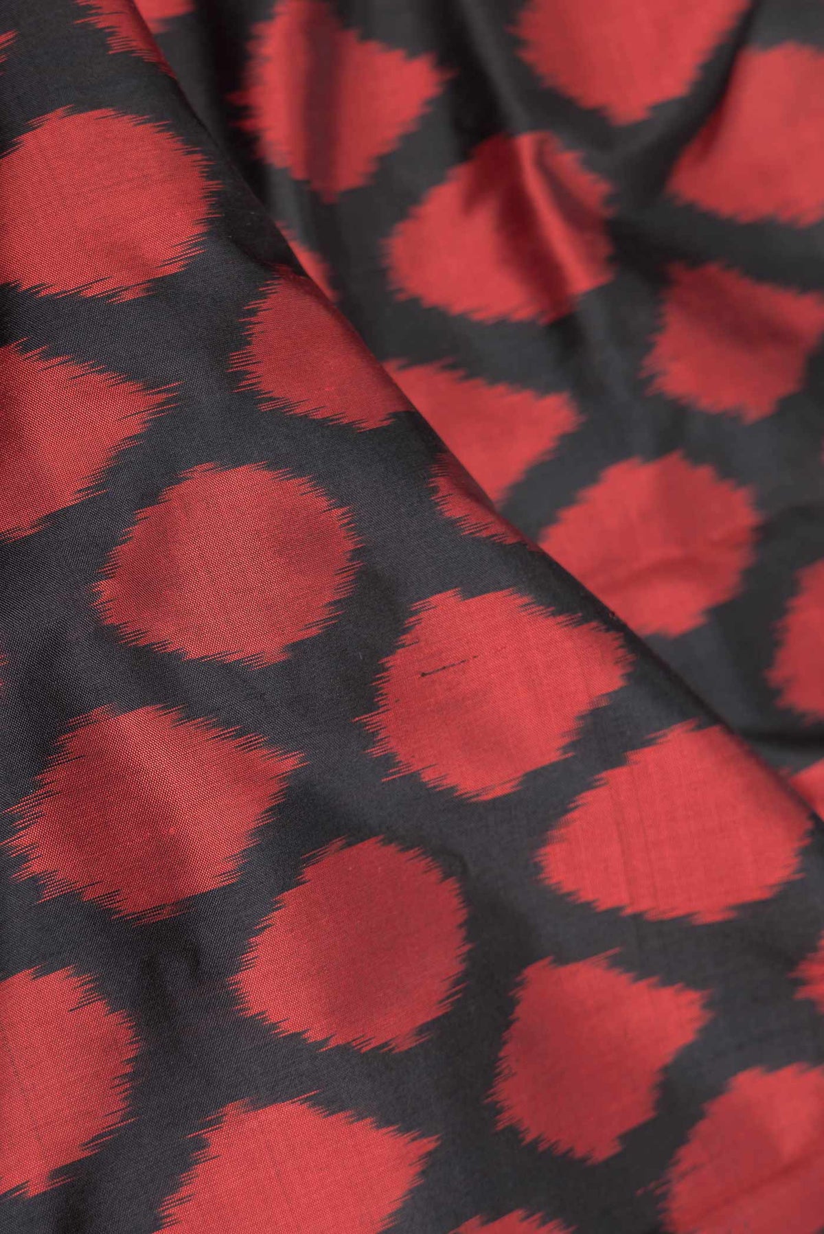 Close up of Black Dual Tone Double Ikat Saree with Ikat Print on the body and Zari Border displaying folds
