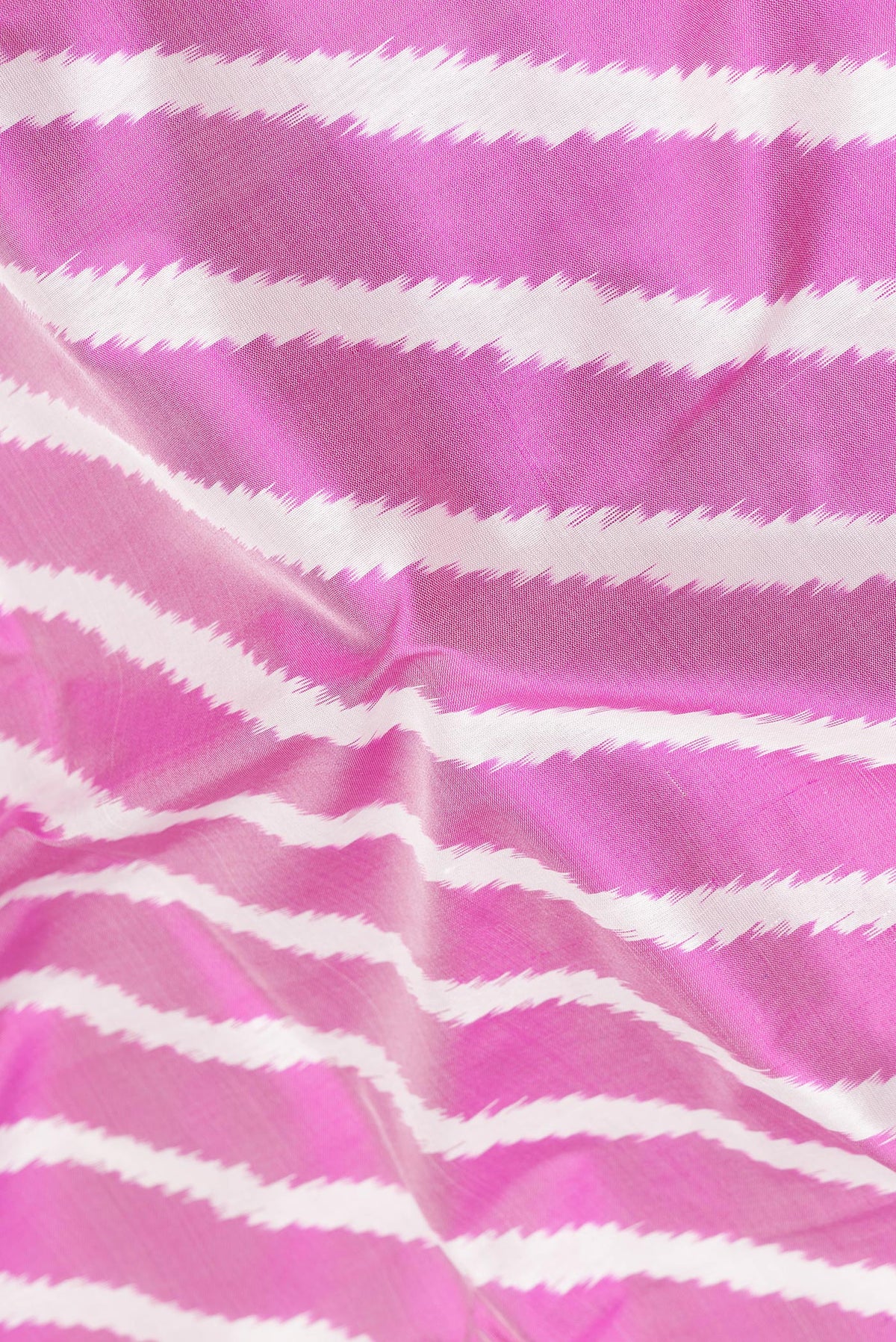 Close up of Pure Silk Pink Pochampally Saree with Ikat design on the body and Ikat Border.  displaying folds
