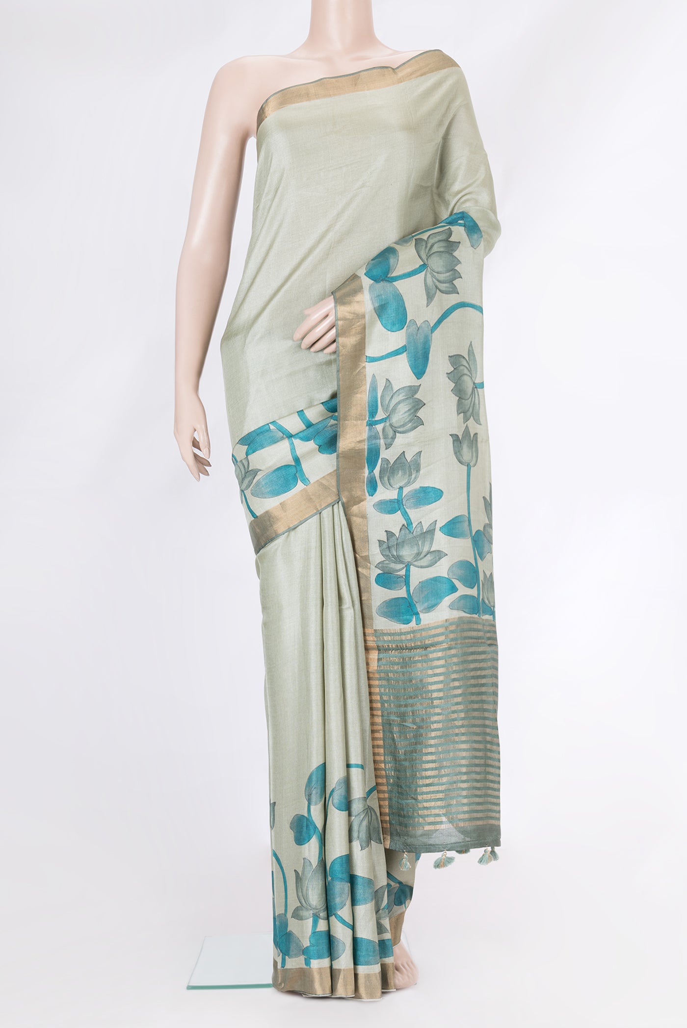 Light Green Tussar Silk Saree with Printed design on the body and Zari Border.  displayed on a mannequin