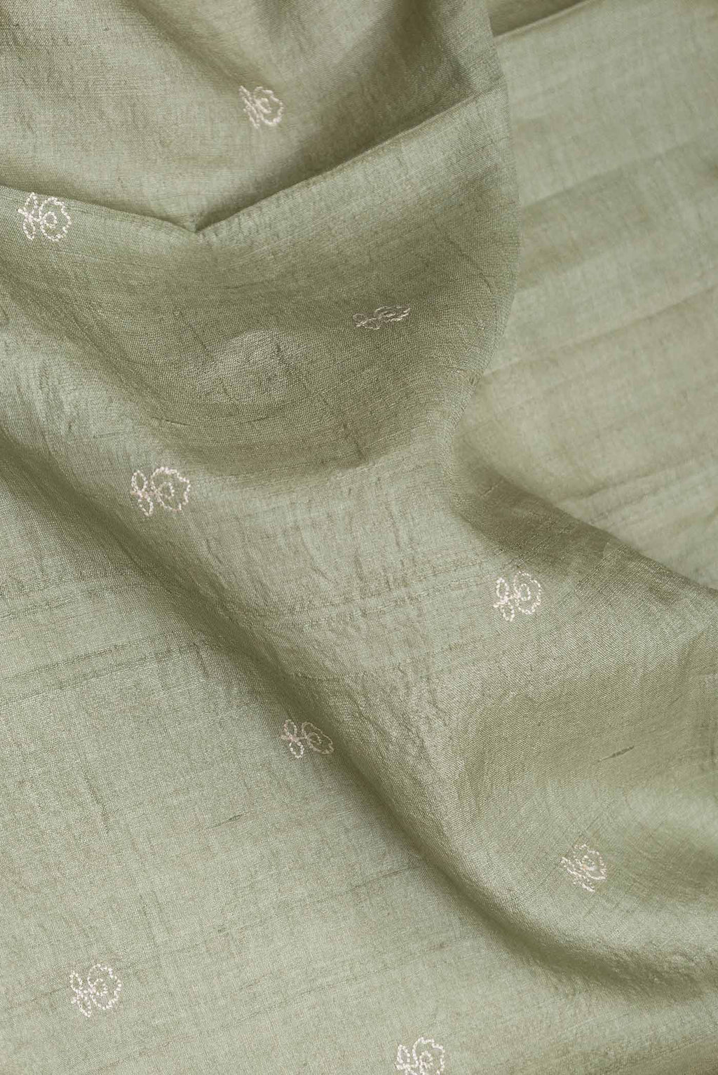 Close up of Sage Green Tussar Silk Saree with Embroidery on the body and Embroidery Border displaying folds