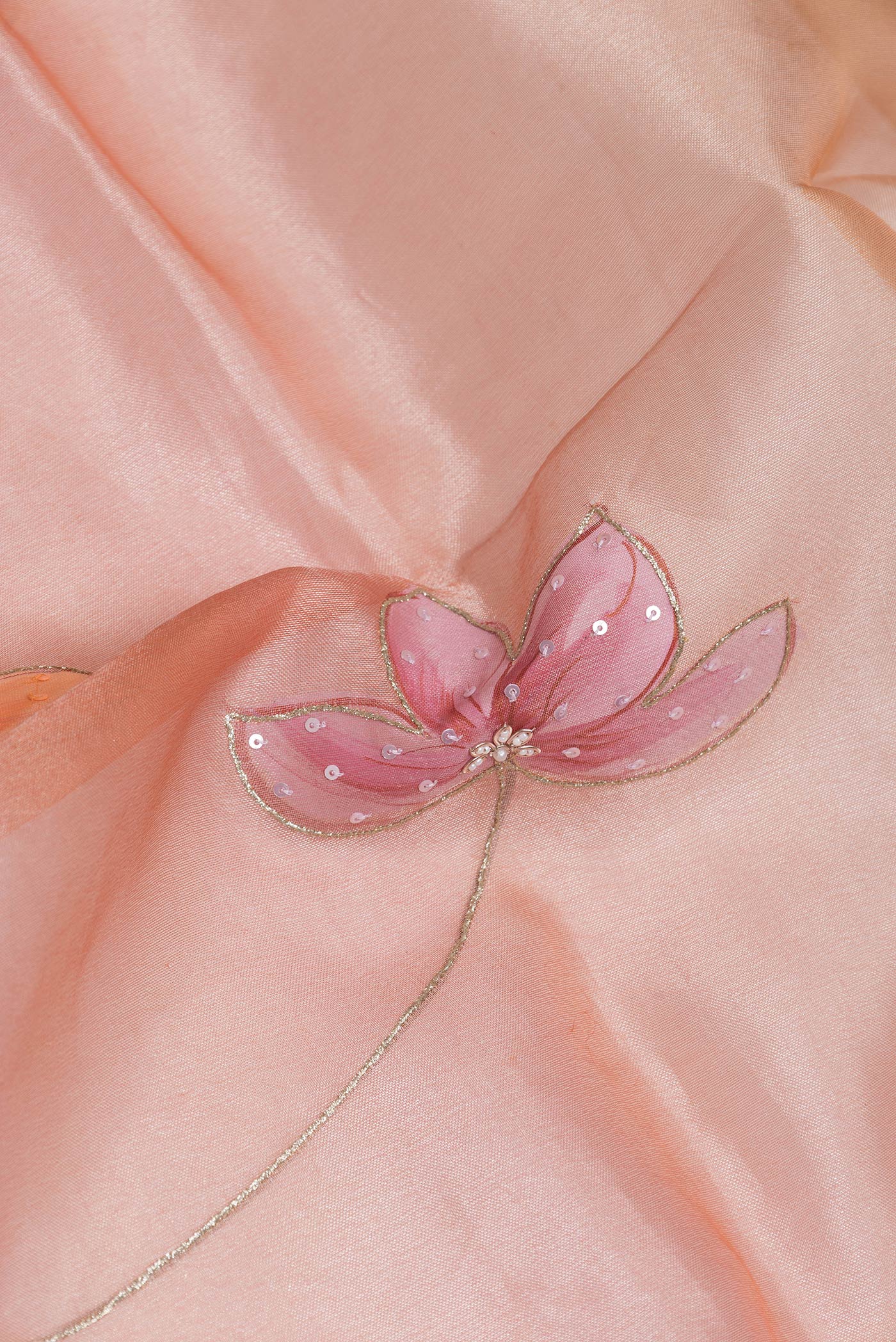Close up of Rose Gold Dual Tone Organza Silk Saree with Embroidery on the body and Embroidery Border.  displaying folds