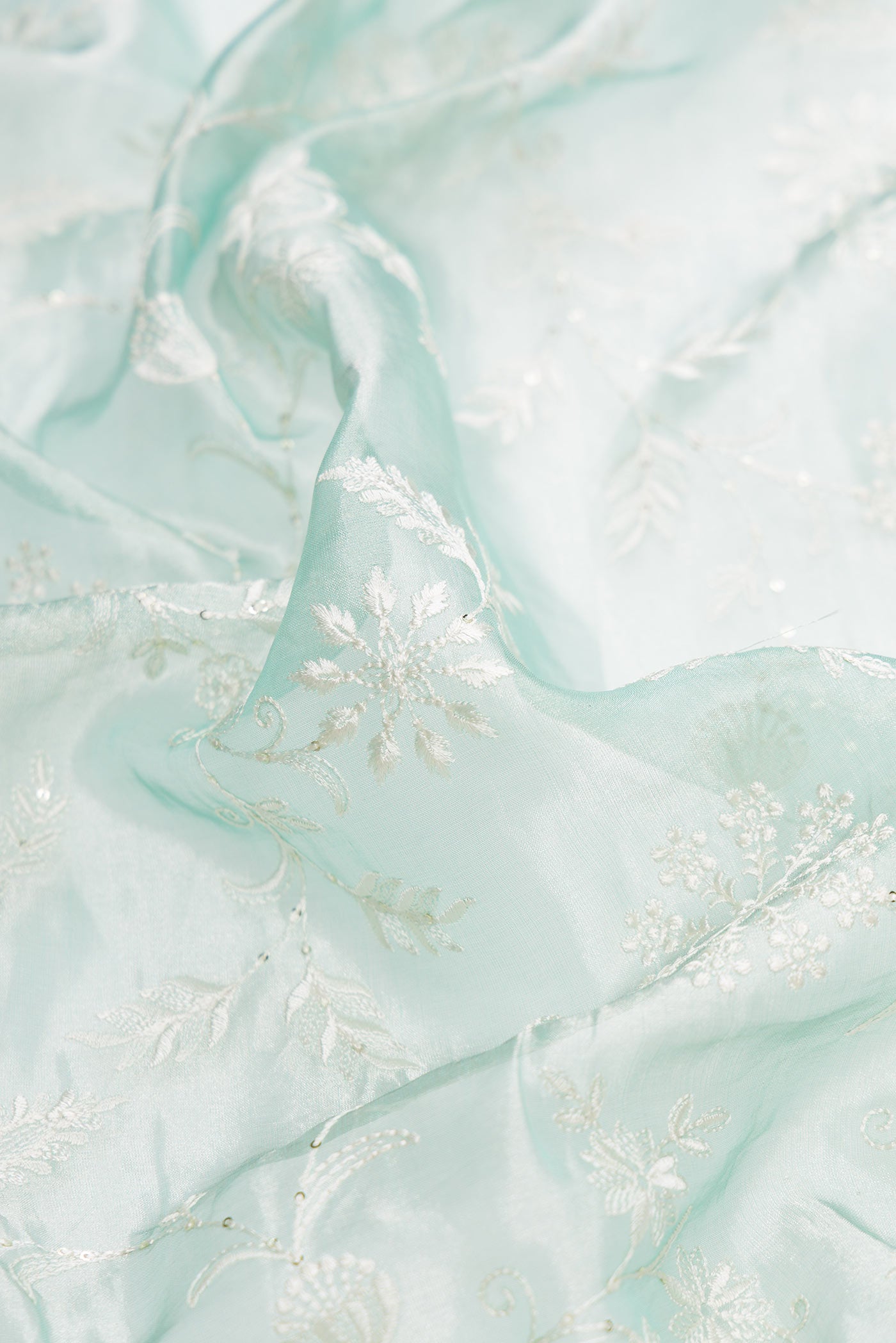 Close up of Sea Green Dual Tone Organza Silk Saree with Embroidery on the body and Embroidery Border.  displaying folds