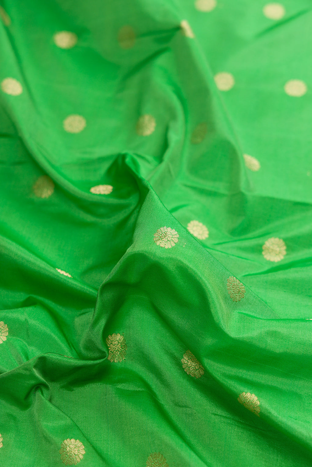 Close up of Parrot Green Dual Tone Paithani Silk Saree with Zari Butta on the body and Zari And Thread Border.  displaying folds