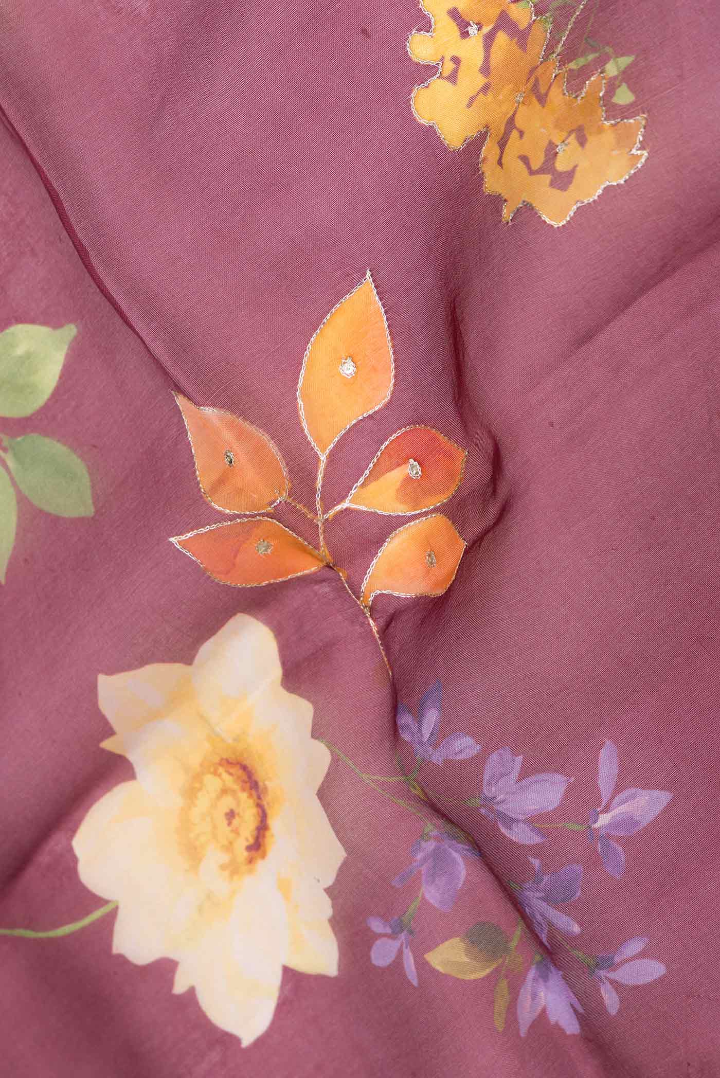 Close up of Maroon Dual Tone Organza Silk Saree with Printed design on the body and Embroidery Border displaying folds
