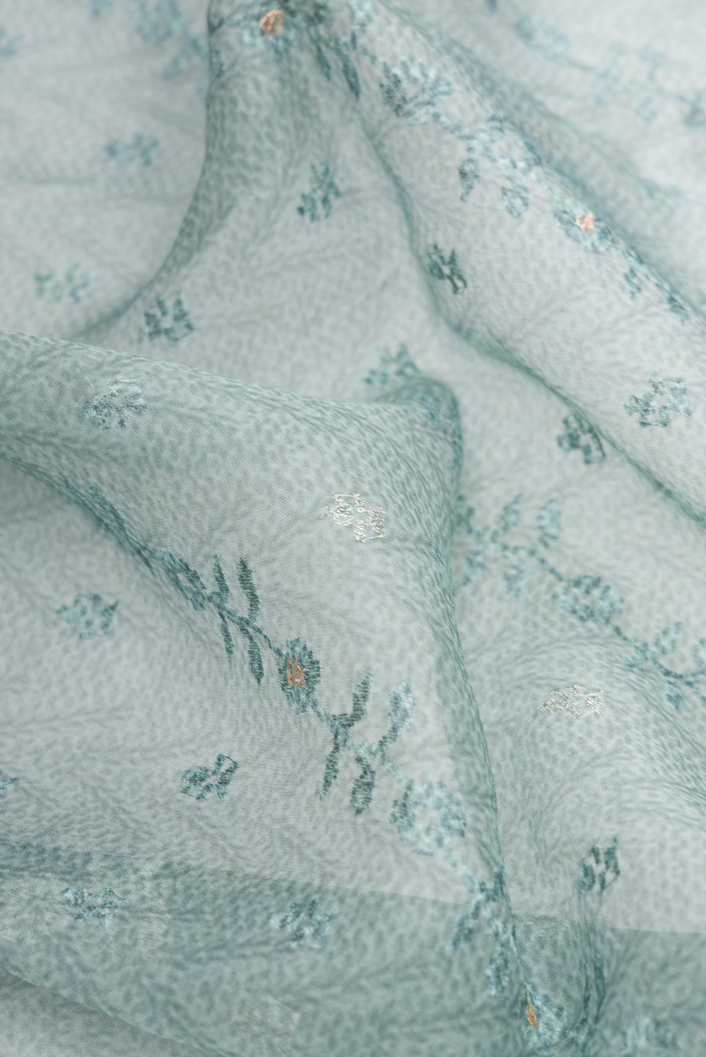 Close up of Blue Dual Tone Organza Silk Saree with Printed design on the body and Embroidery Border.  displaying folds