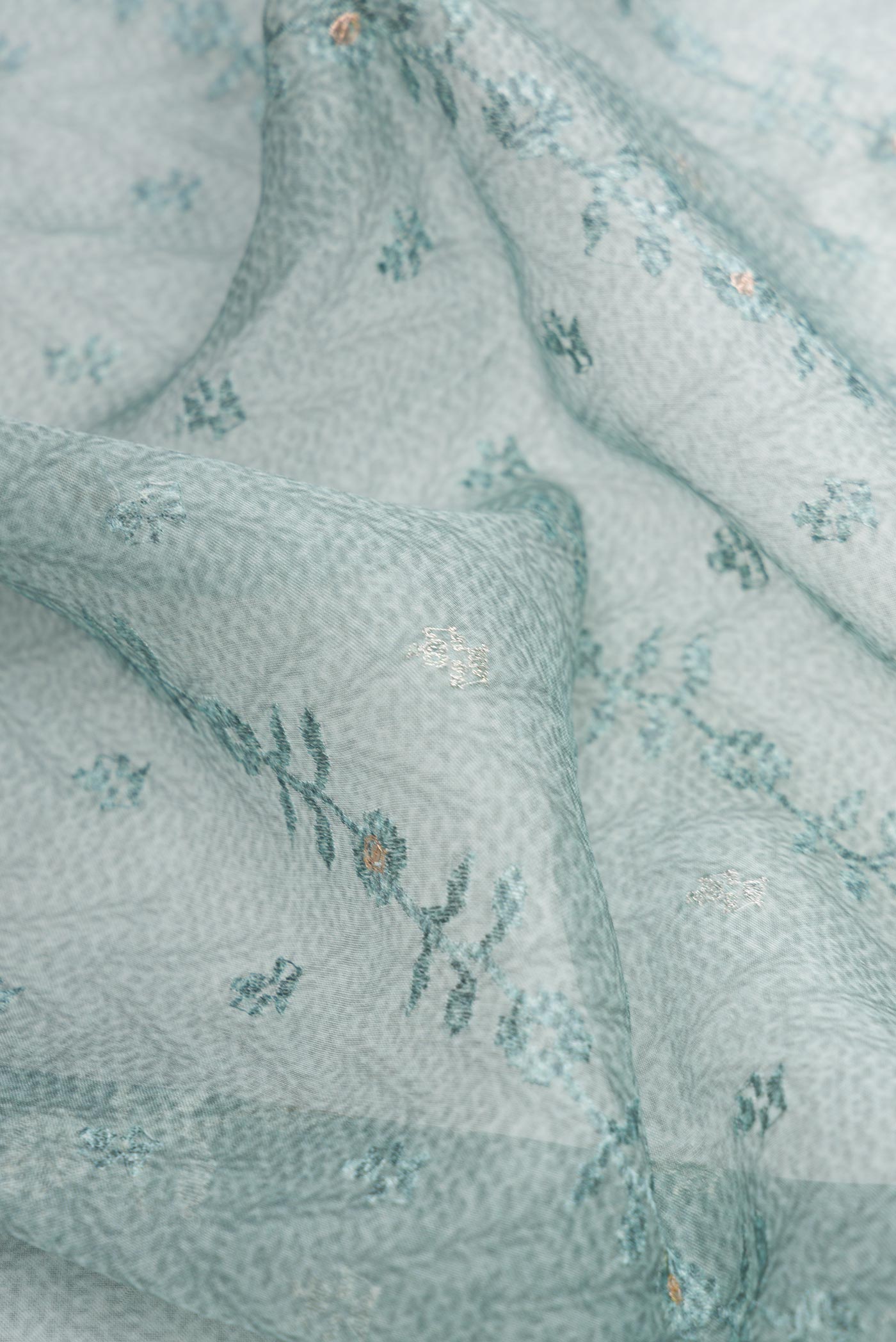 Close up of Blue Dual Tone Organza Silk Saree with Printed design on the body and Embroidery Border.  displaying folds