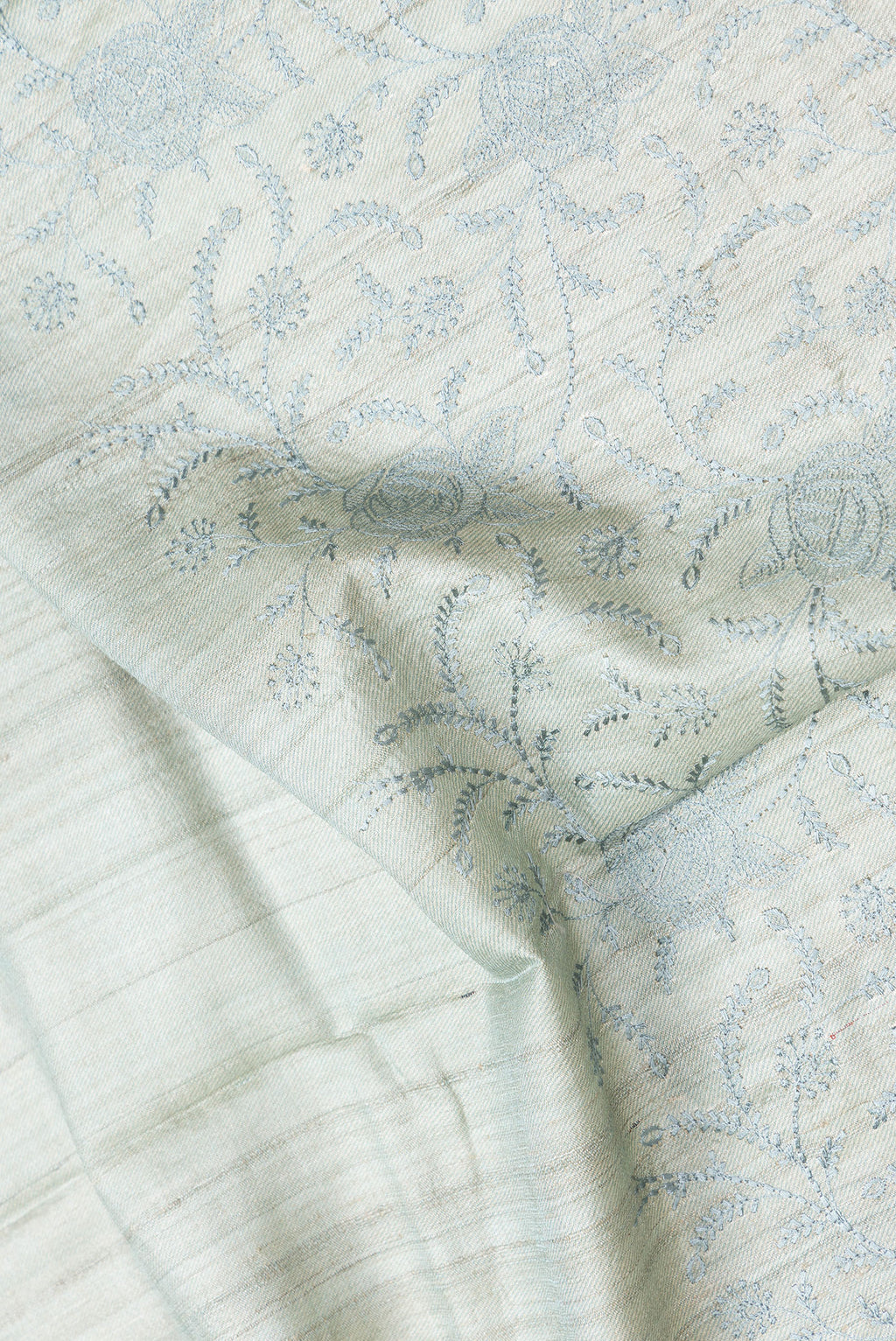 Close up of Sea Green Dual Tone Tussar Silk Saree with Embroidery on the body and Printed Border.  displaying folds