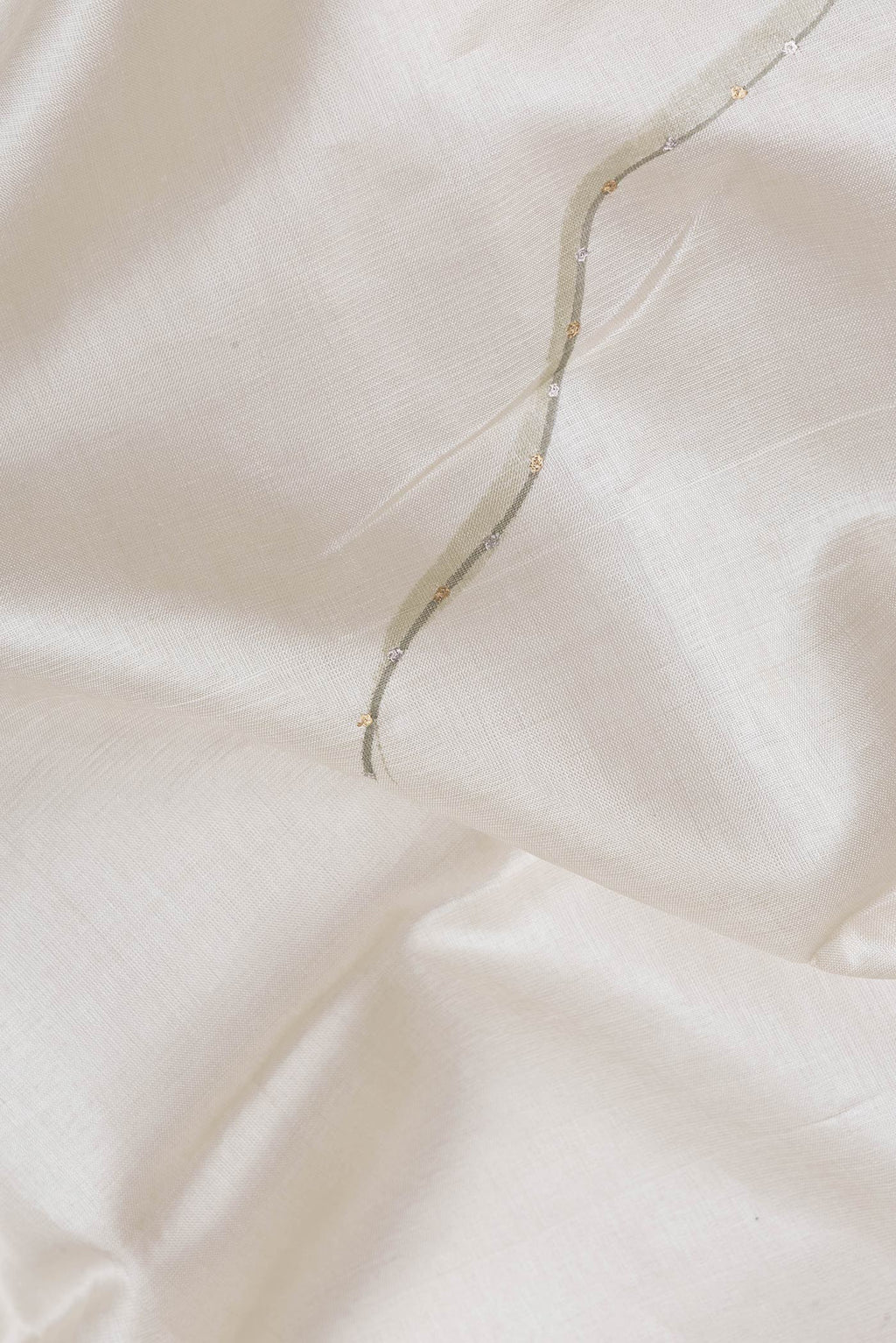 Close up of Beige Dual Tone Tussar Silk Saree with Plain Body and Fancy Border.  displaying folds