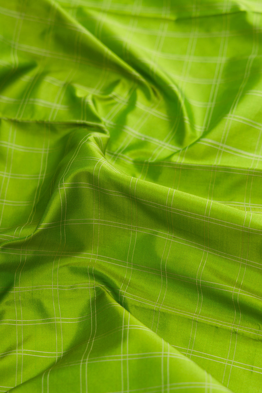 Close up of Parrot Green Dual Tone Kanjivaram Silk Saree with Checked design on the body and Zari Border.  displaying folds