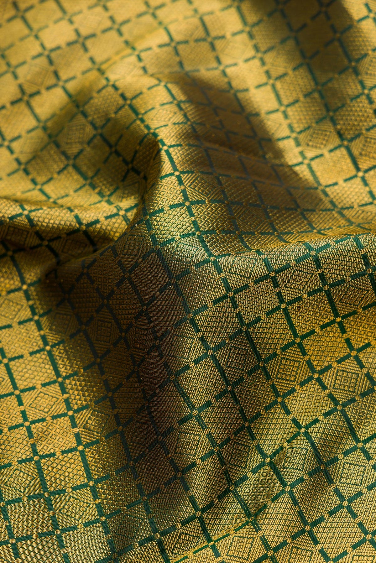 Close up of Bottle Green Dual Tone Kanjivaram Silk Saree with Zari Brocade on the body and Zari Border.  displaying folds