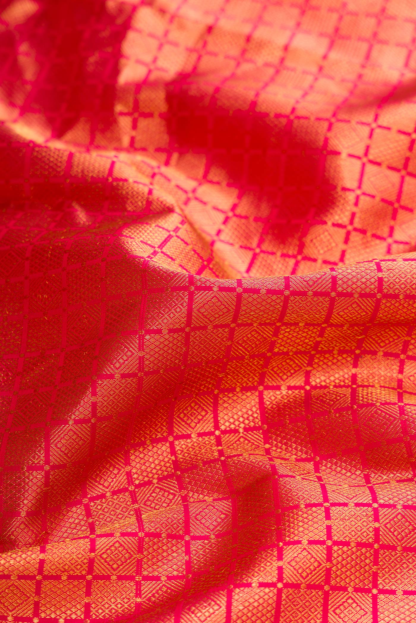 Close up of Brick Orange Dual Tone Kanjivaram Silk Saree with Zari Brocade on the body and Zari Border.  displaying folds