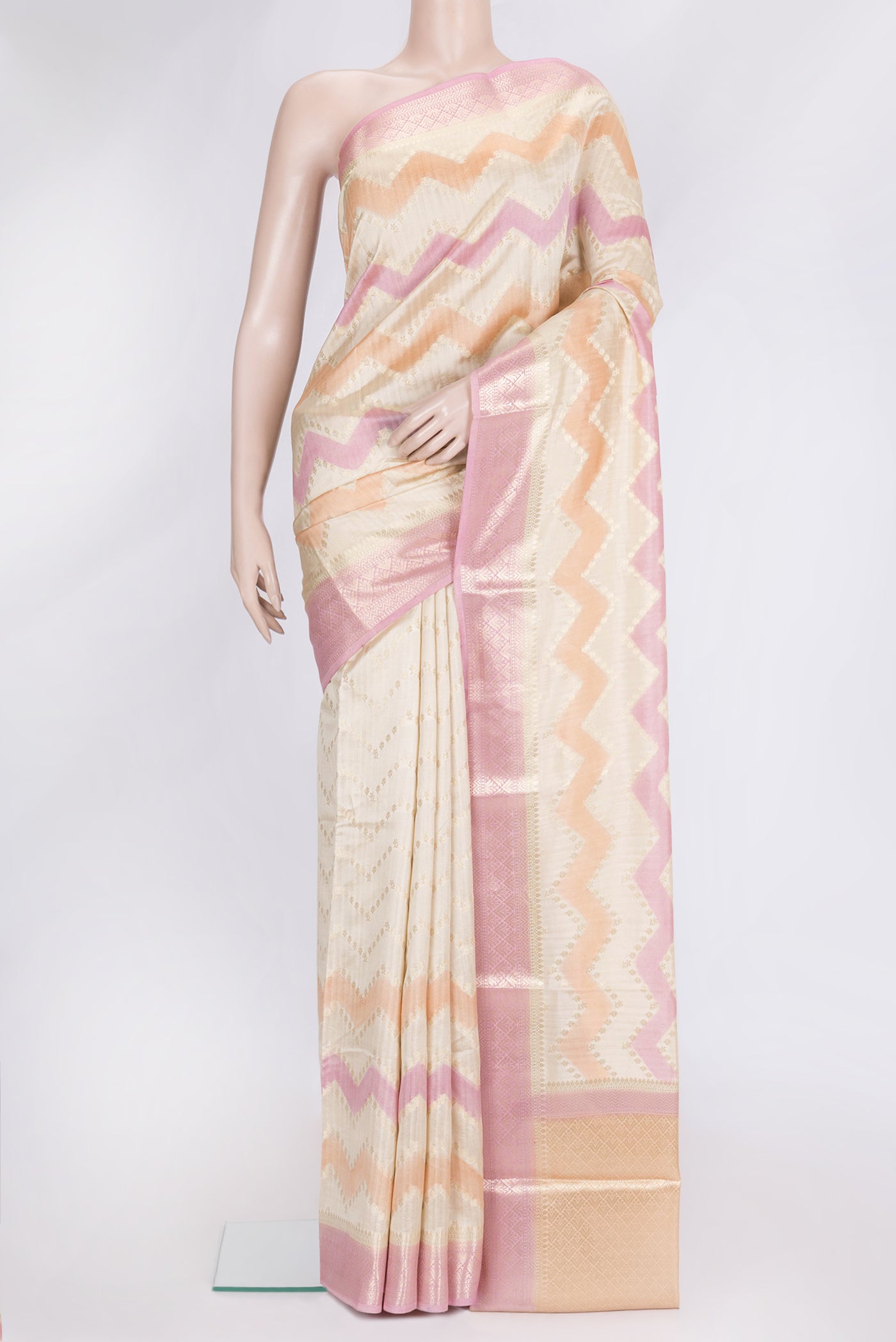 Pink, Orange and Sandal Color Tussar Silk Saree with Zig Zag design on the body and Zari Border.  displayed on a mannequin