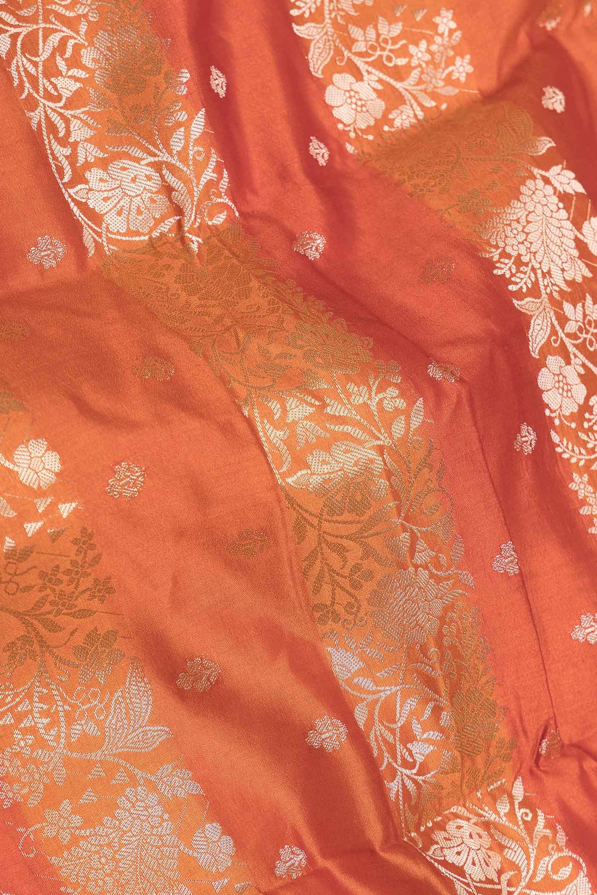 Close up of Orange Banarasi Raw Silk Saree with Stripes on the body and Zari Border displaying folds