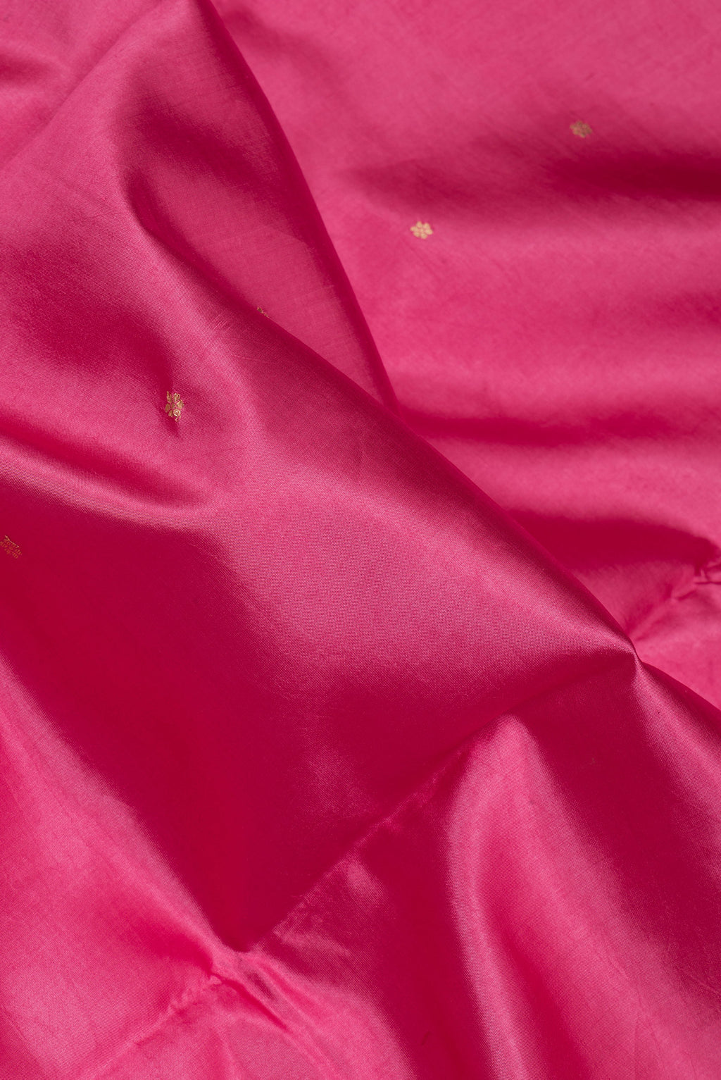 Close up of Pink Tussar Silk Saree with Zari Butta on the body and Fancy Border.  displaying folds