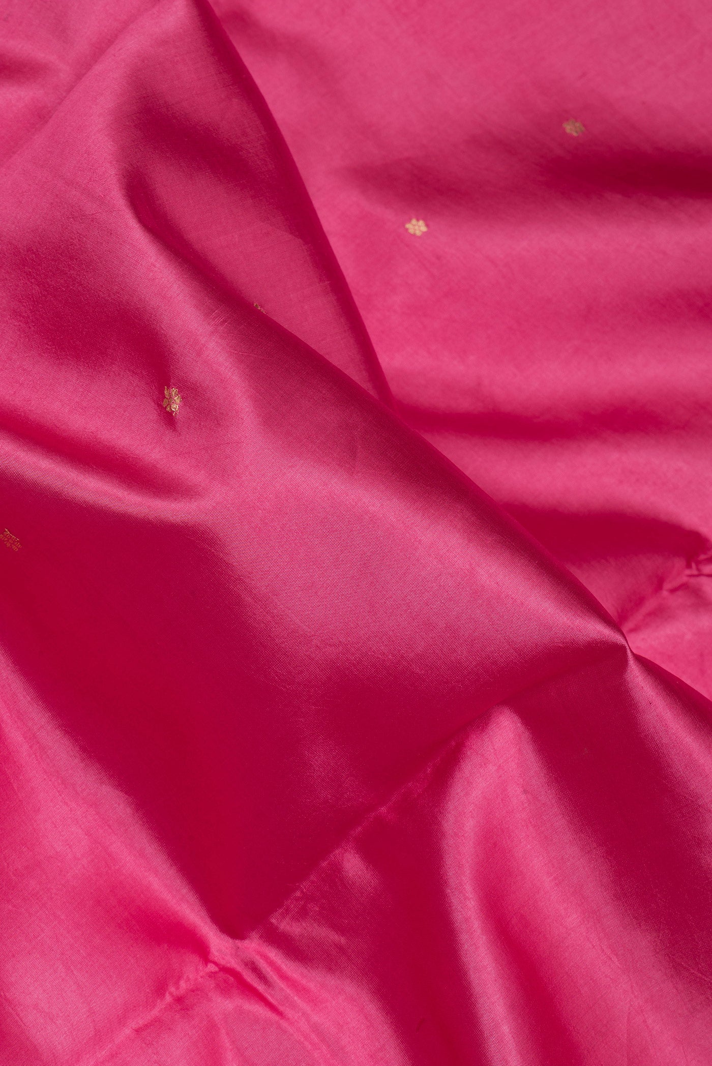 Close up of Pink Tussar Silk Saree with Zari Butta on the body and Fancy Border.  displaying folds
