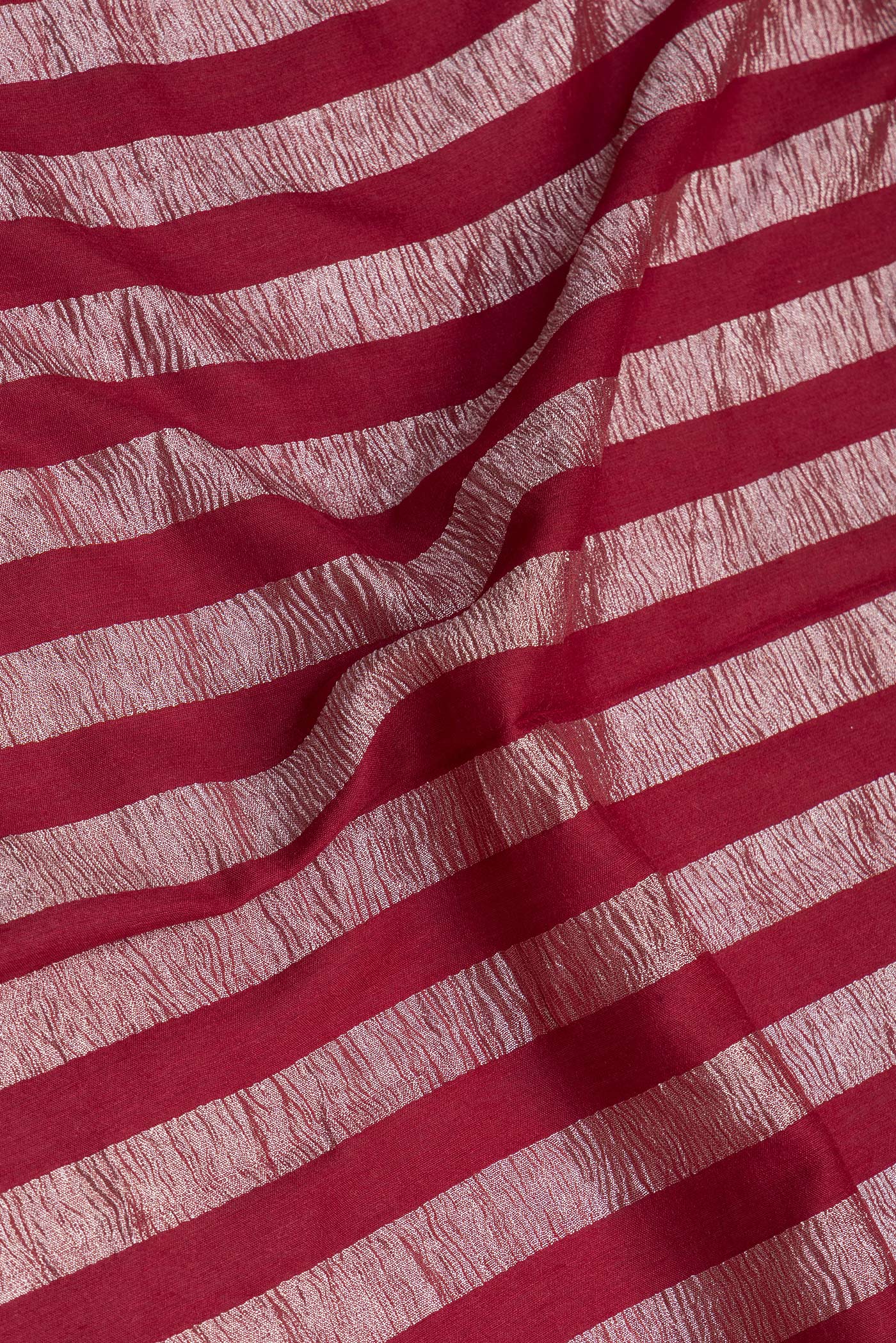 Close up of Maroon Tussar Silk Saree with Stripes on the body and Zari Border.  displaying folds