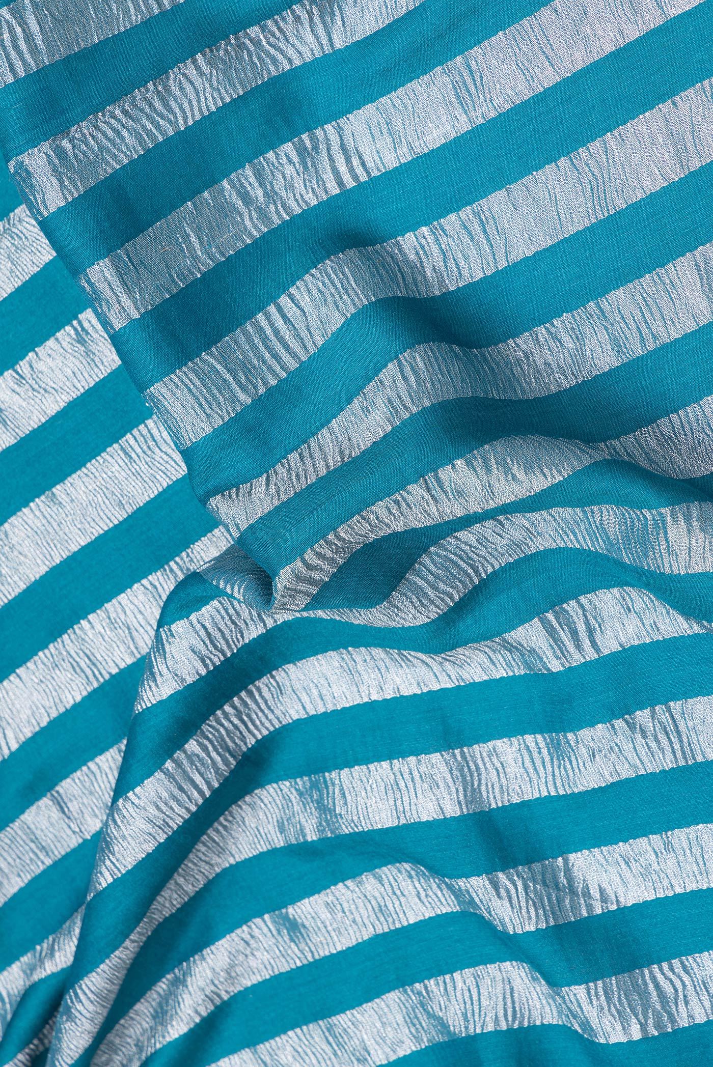 Close up of Sky Blue Dual Tone Tussar Silk Saree with Stripes on the body and Zari Border.  displaying folds