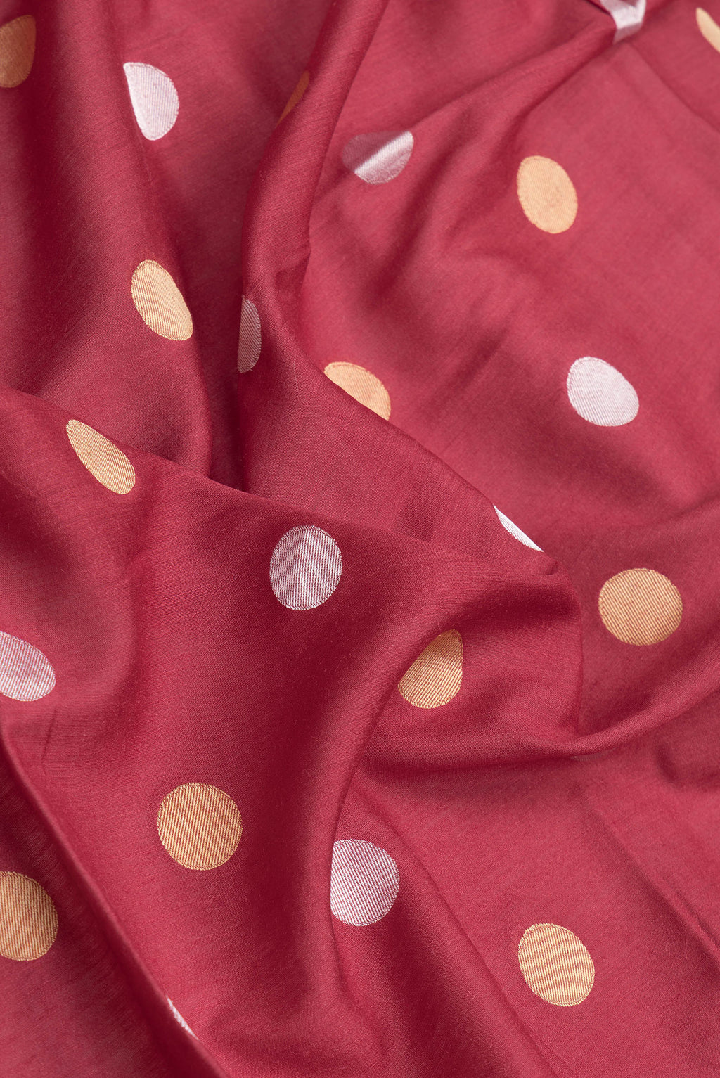 Close up of Maroon Dual Tone Tussar Silk Saree with Zari Butta on the body and Zari Border.  displaying folds