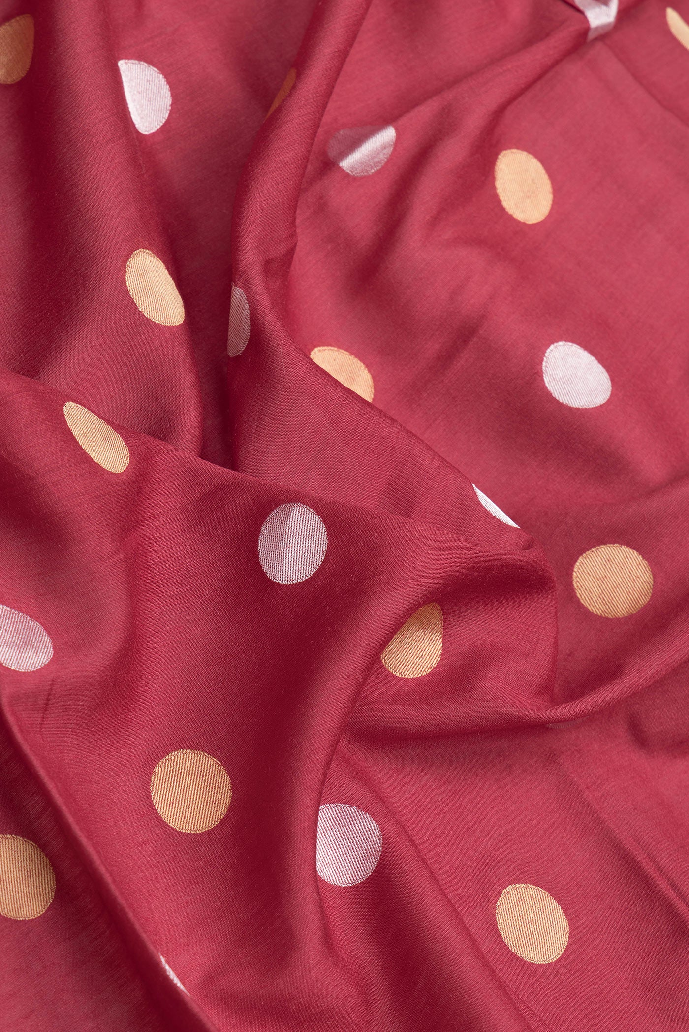 Close up of Maroon Dual Tone Tussar Silk Saree with Zari Butta on the body and Zari Border.  displaying folds