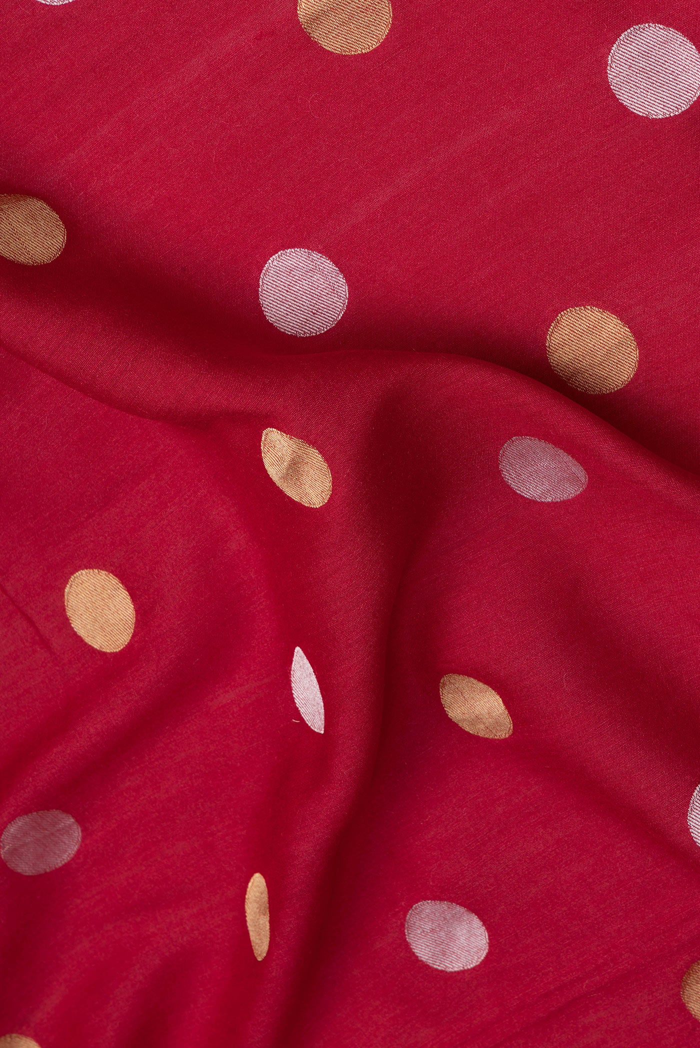 Close up of Red Tussar Silk Saree with Polka Dots on the body and Zari Border.  displaying folds