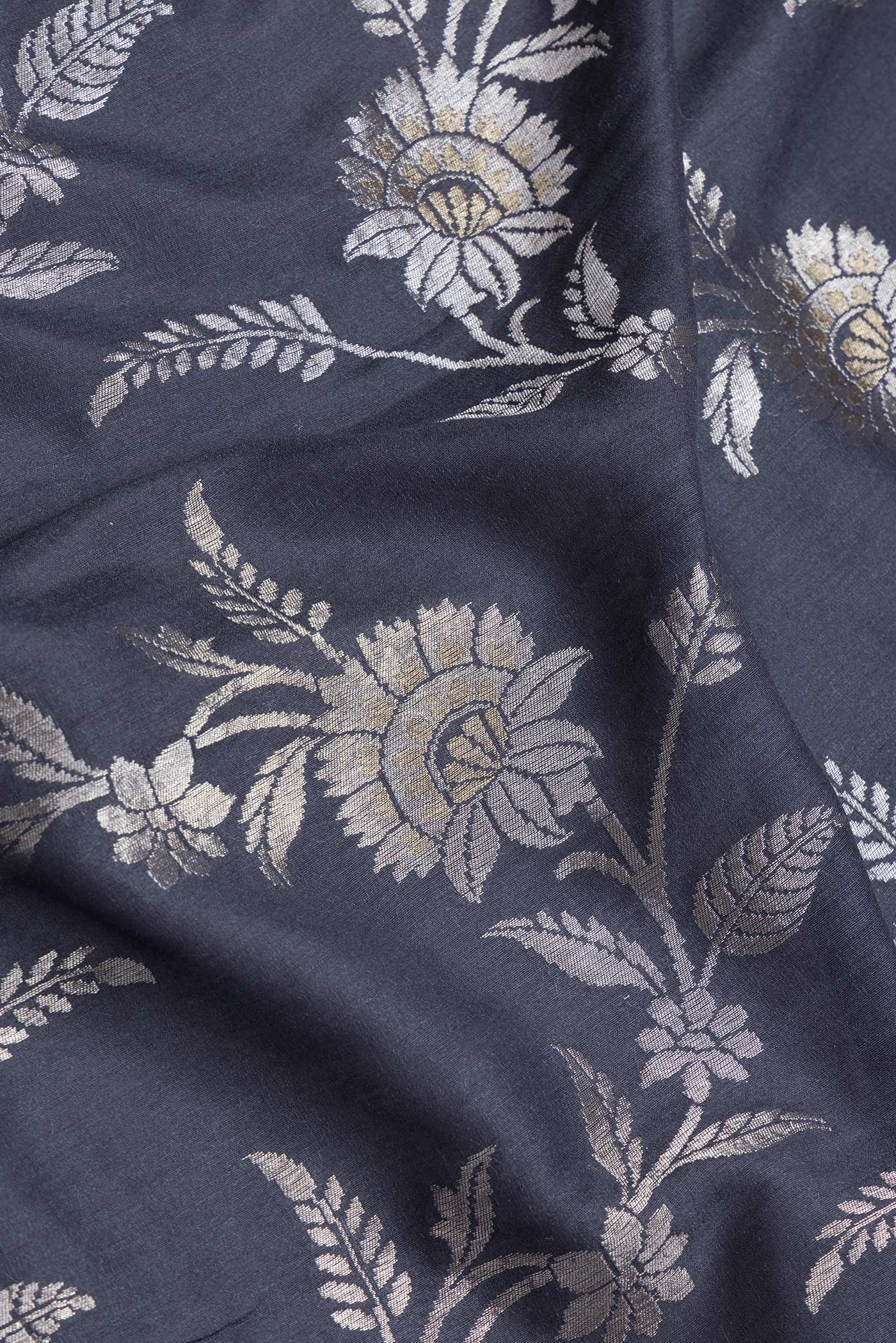 Close up of Grey Dual Tone Tussar Silk Saree with Zari Brocade on the body and Zari Border.  displaying folds