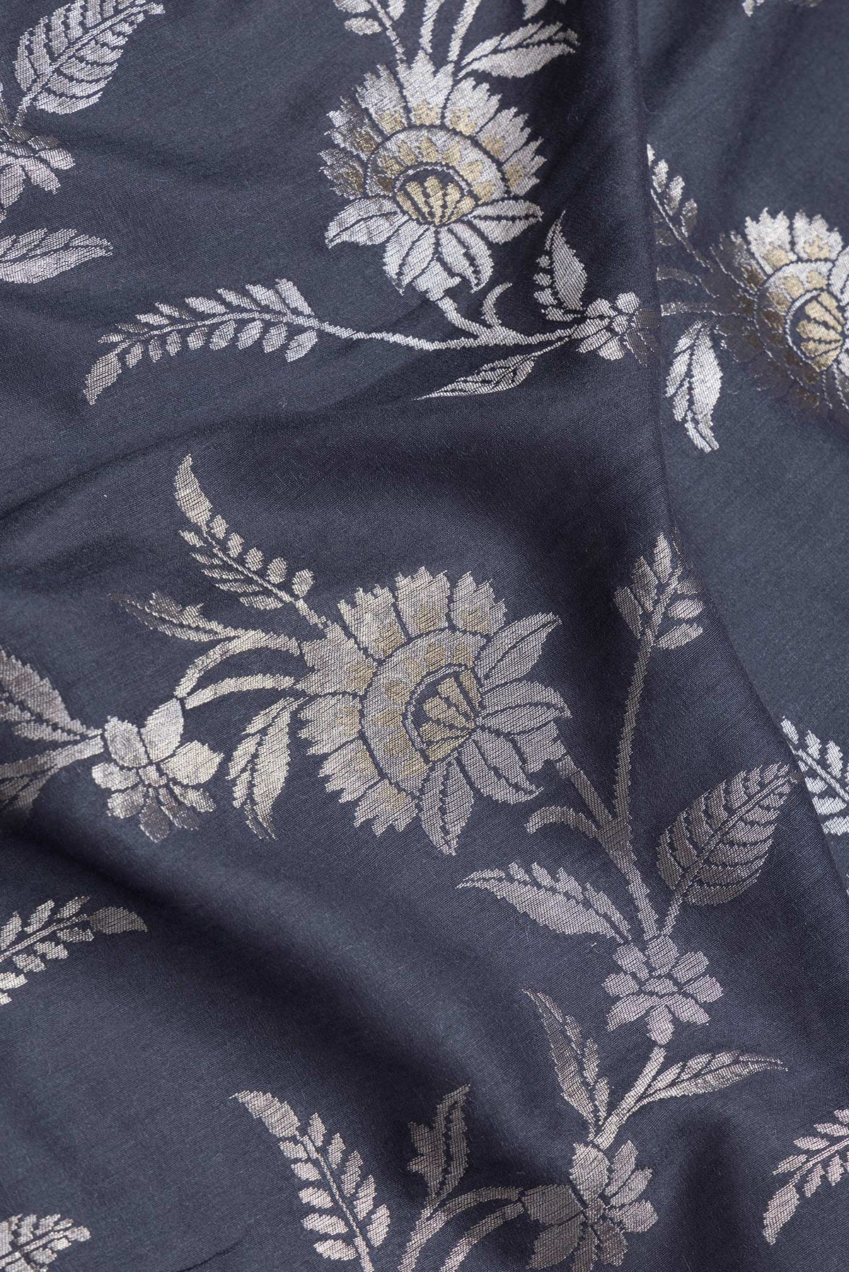 Close up of Grey Dual Tone Tussar Silk Saree with Zari Brocade on the body and Zari Border.  displaying folds