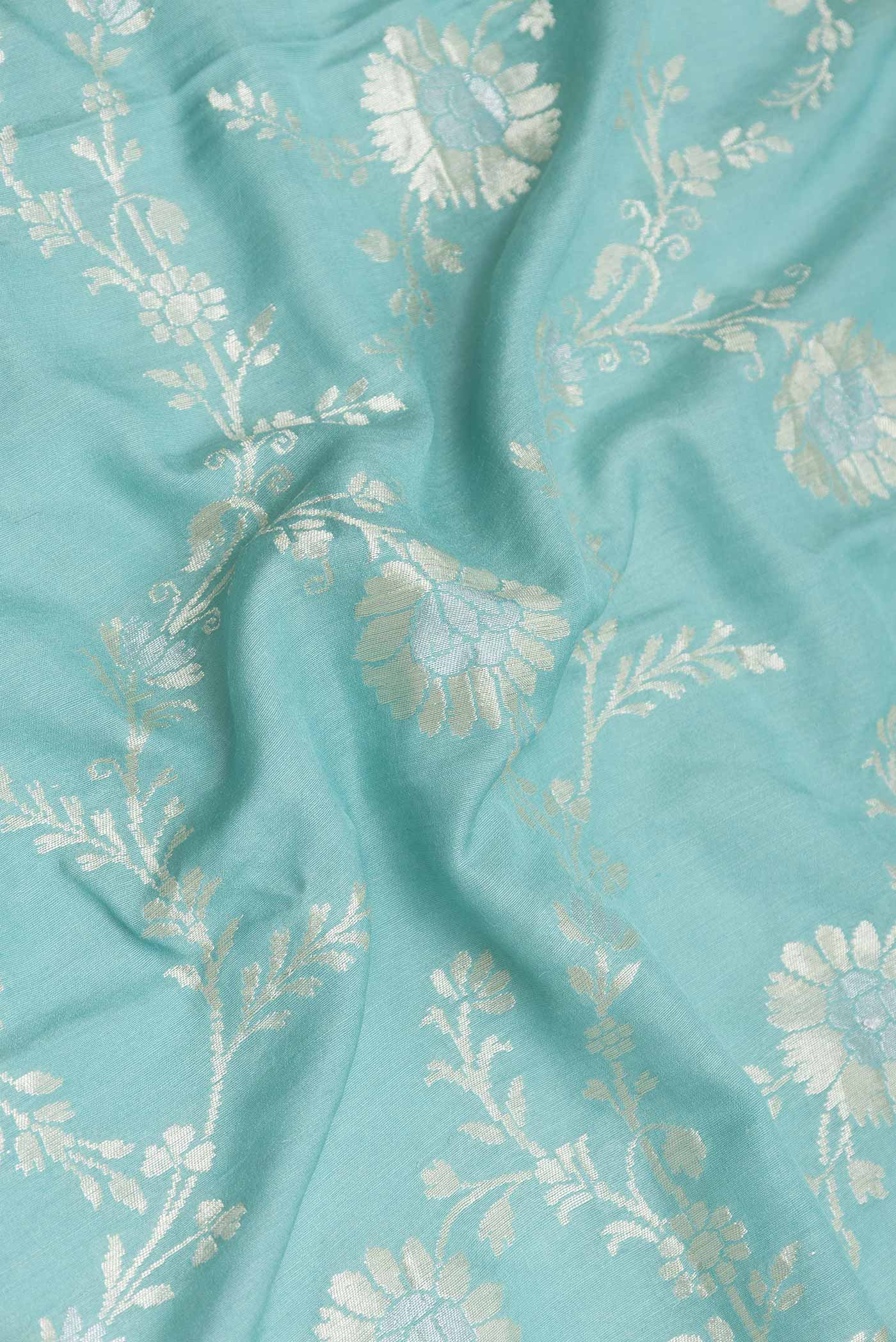 Close up of Light Blue Dual Tone Tussar Silk Saree with Zari Butta on the body and Zari Border displaying folds