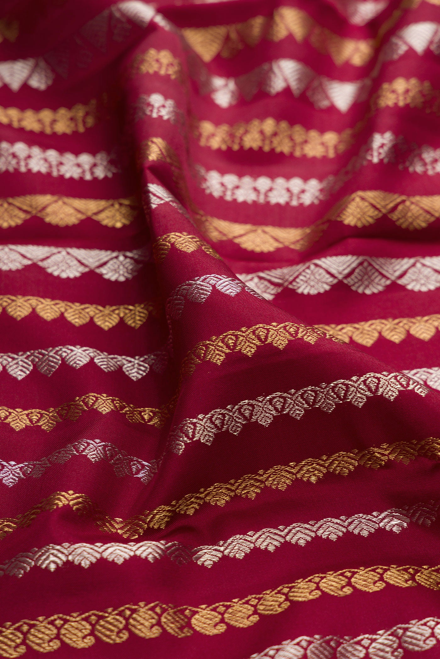 Close up of Maroon Kanchipuram Silk Saree with Zari Brocade on the body and Thread Border.  displaying folds