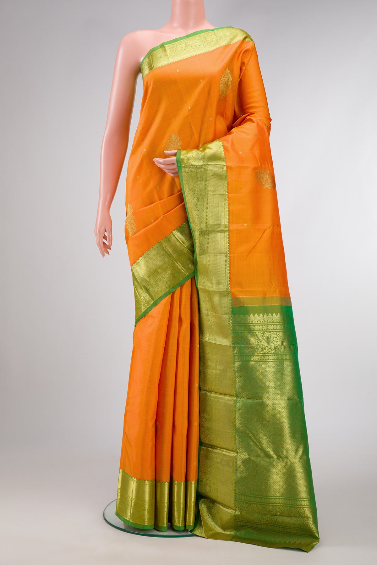 Orange Dual Tone Kanjivaram Silk Saree with Zari Butta on the body and Zari Border.  displayed on a mannequin