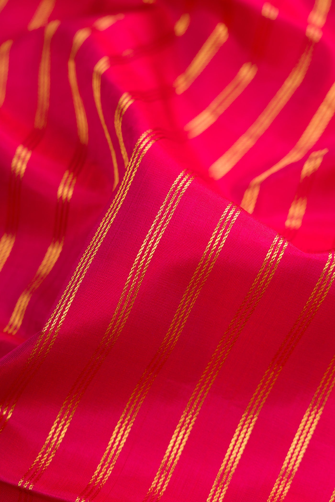 Close up of Dark Pink Kanchipuram Silk Nine Yards Saree with Stripes on the body and Zari Border.  displaying folds