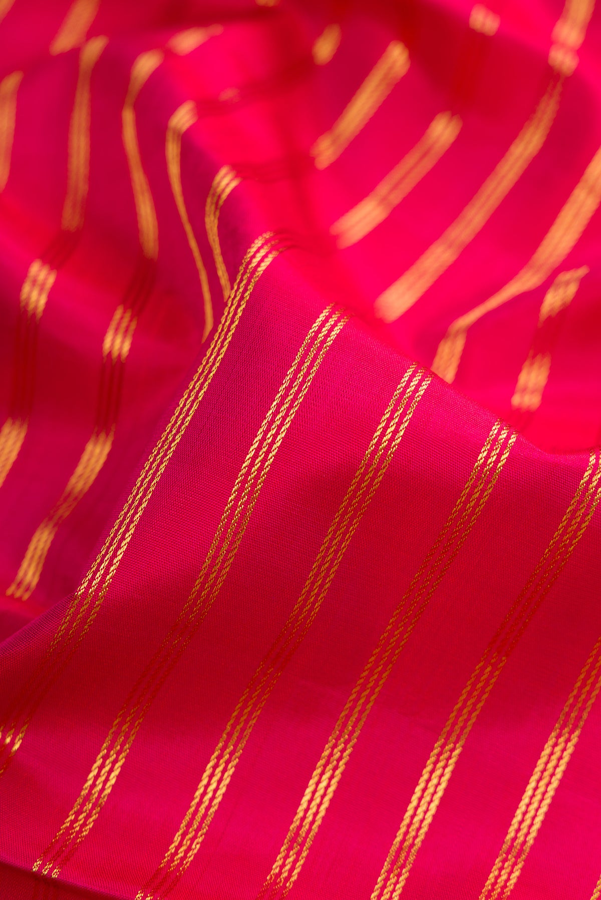 Close up of Dark Pink Kanchipuram Silk Nine Yards Saree with Stripes on the body and Zari Border.  displaying folds