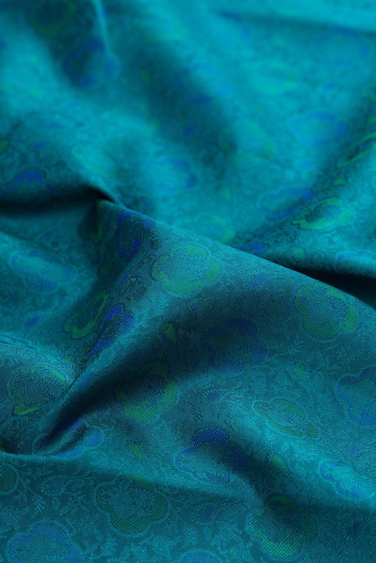 Close up of Pure Silk Pure Zari Peacock Blue Kanchipuram Saree with Jacquard design on the body and Zari Border.  displaying folds