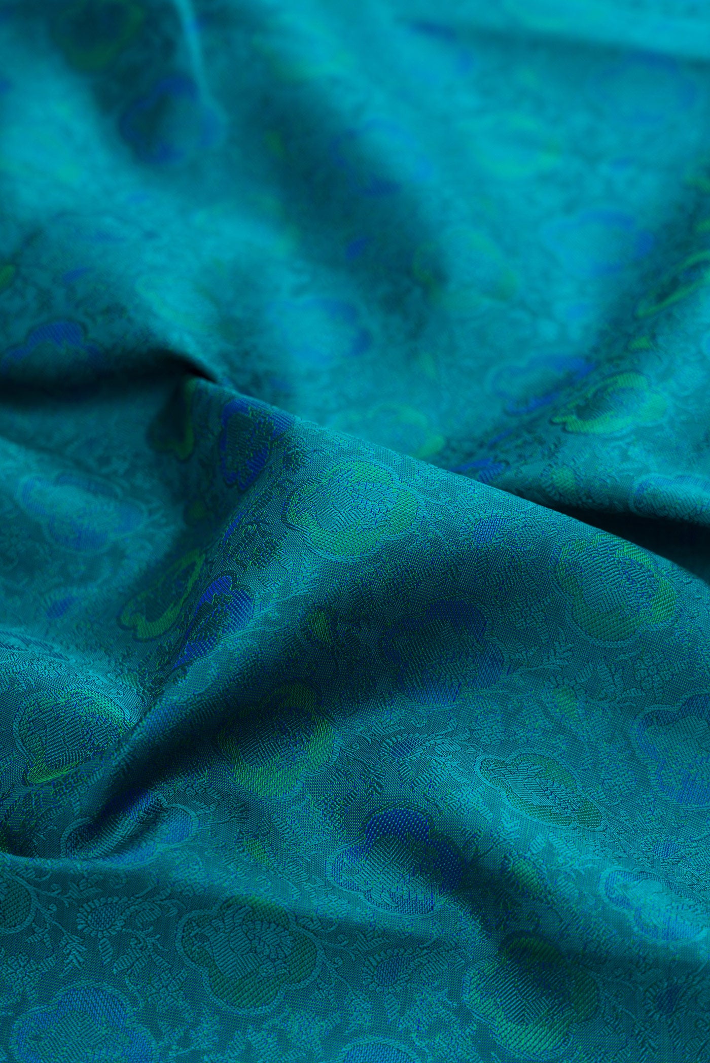 Close up of Pure Silk Pure Zari Peacock Blue Kanchipuram Saree with Jacquard design on the body and Zari Border.  displaying folds