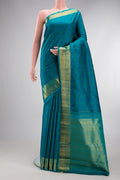Pure Silk Pure Zari Peacock Blue Kanchipuram Saree with Jacquard design on the body and Zari Border.  displayed on a mannequin