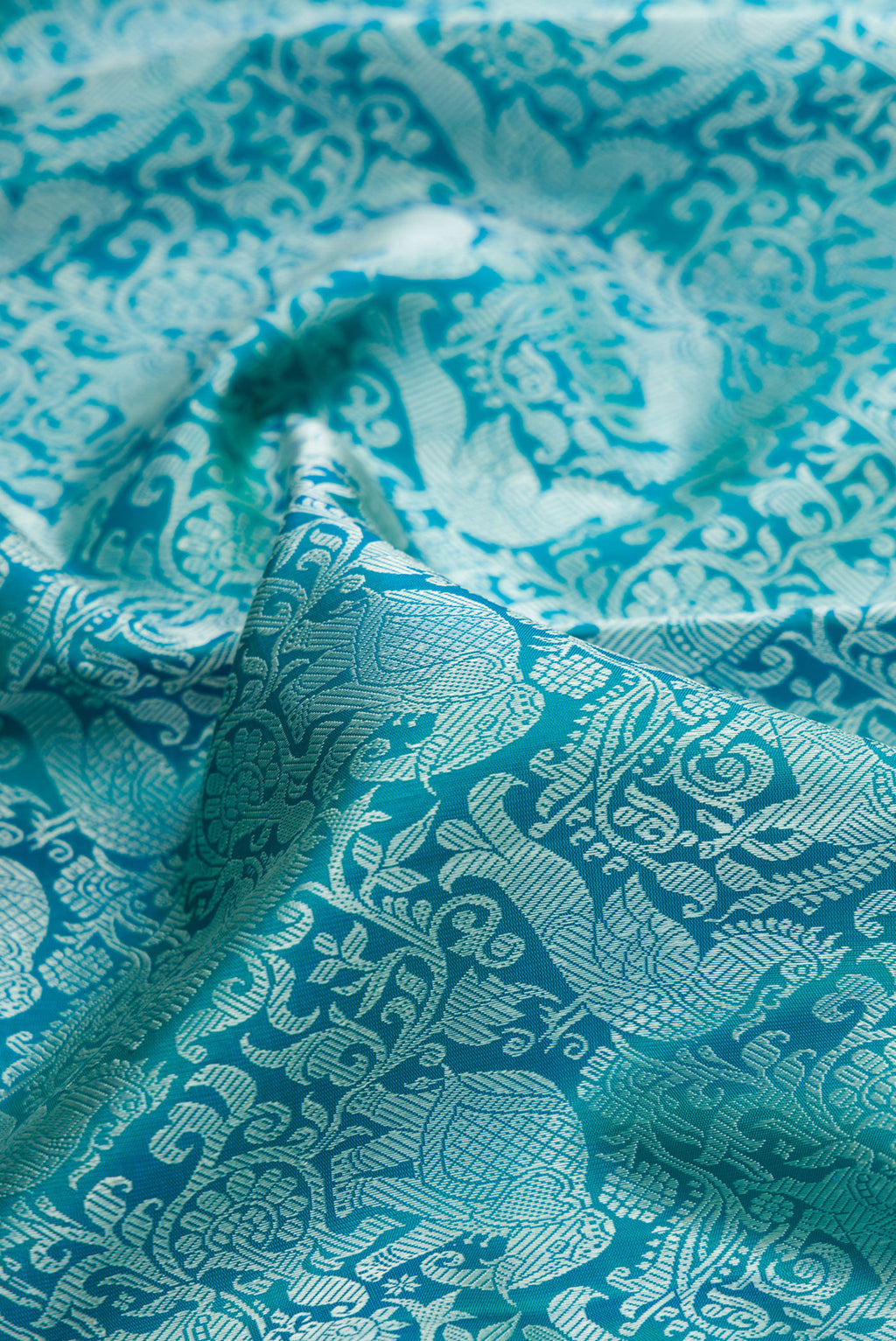 Close up of Pure Silk Pure Zari Peacock Blue Dual Tone Kanchipuram Saree with Jacquard design on the body and Zari Border.  displaying folds