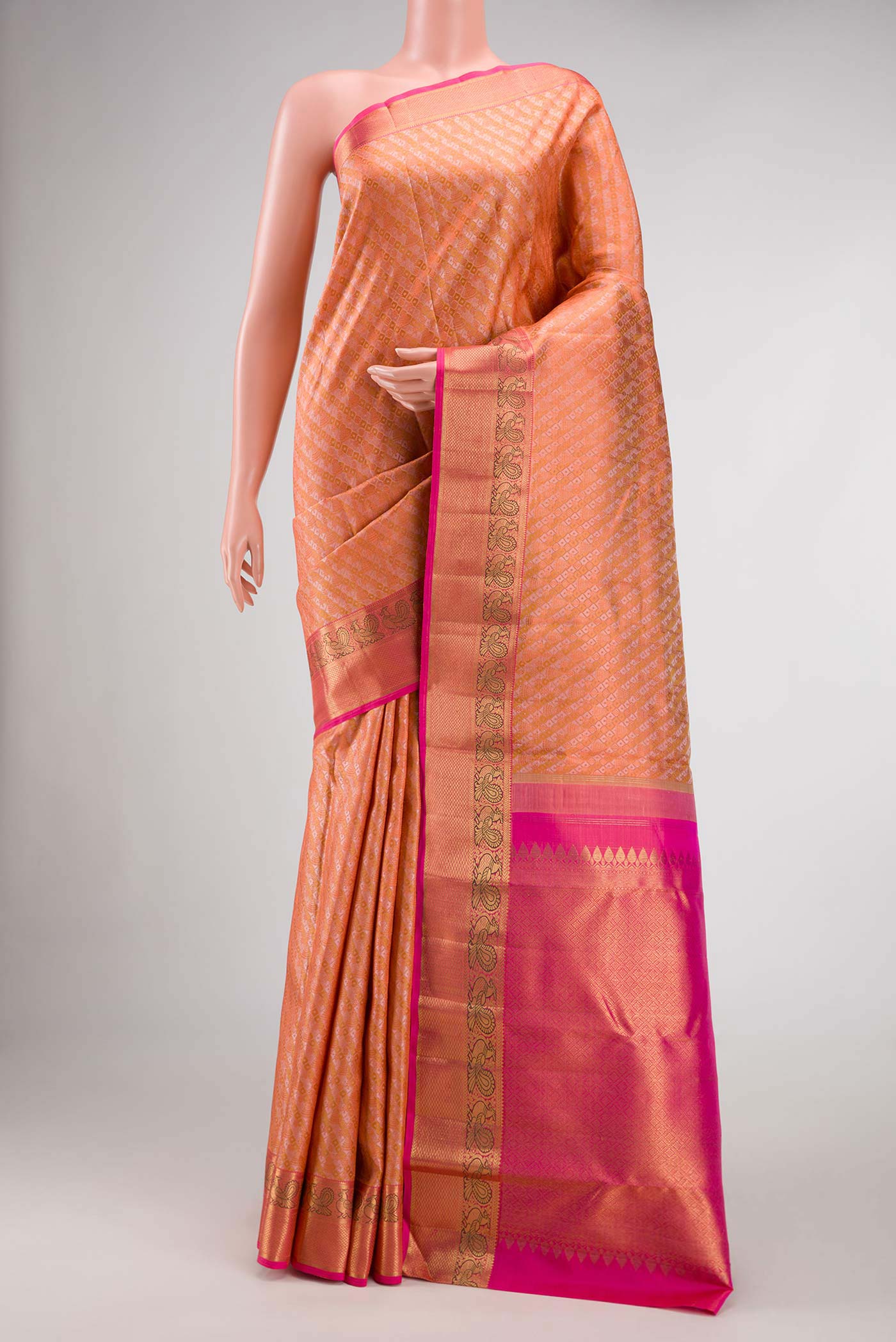 Pure Silk Pure Zari Golden Peach Dual Tone Kanchipuram Saree with Jacquard design on the body and Zari Border.  displayed on a mannequin